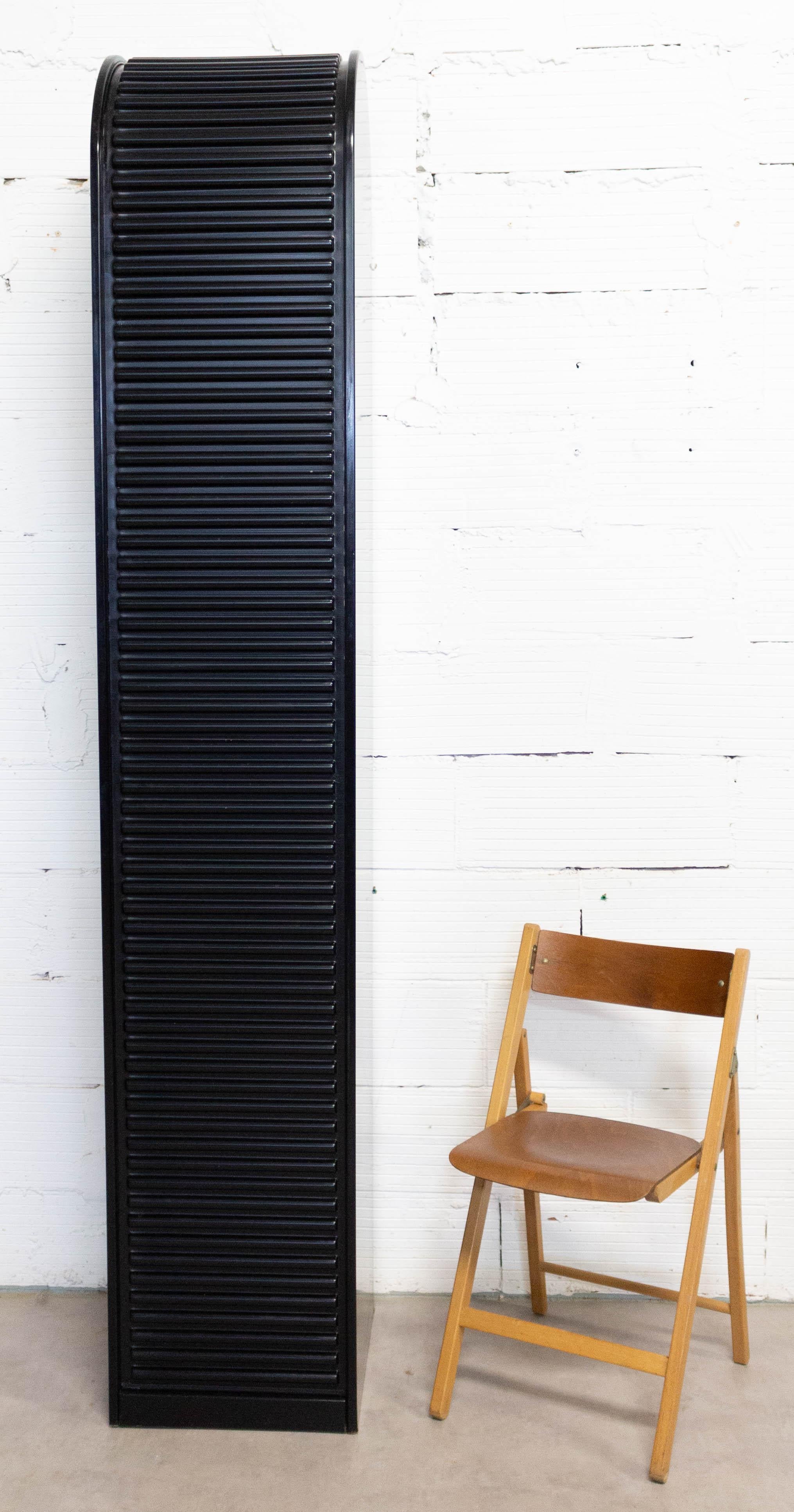 Black cabinet with a roller door and three drawers inside
France, circa 1980
Good condition.

Shipping: 
L 40/ P 45/ H 220 cm 47.6 kg.