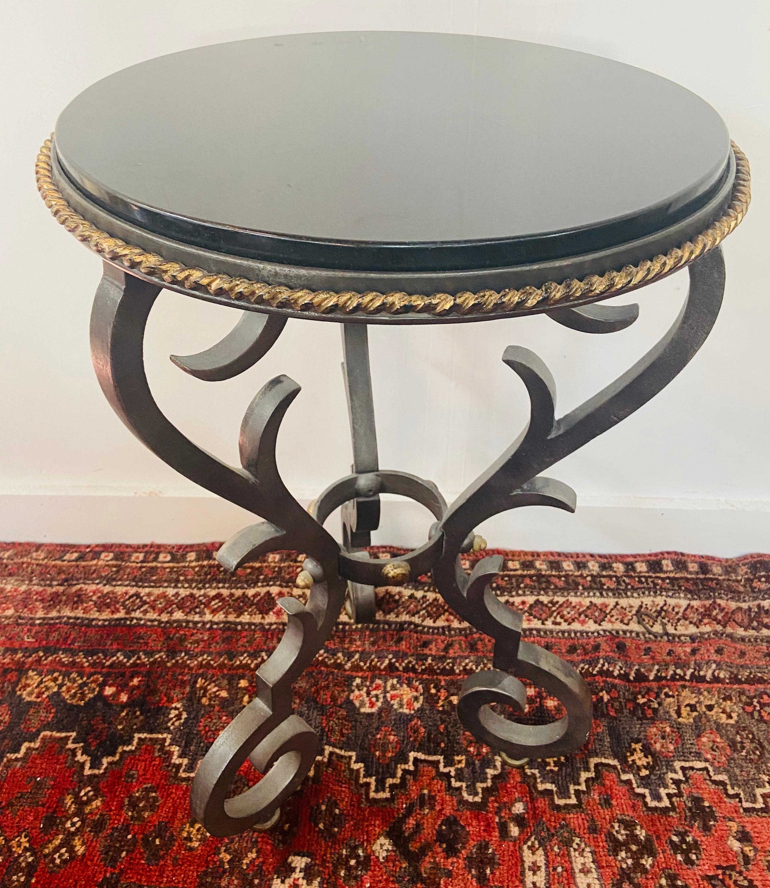 A charming cast iron gueridon table in French Provincial style. With a gold painted rope design frame the circular marble top is sitting on an iron cast base with scroll base. 

Dimensions: 28