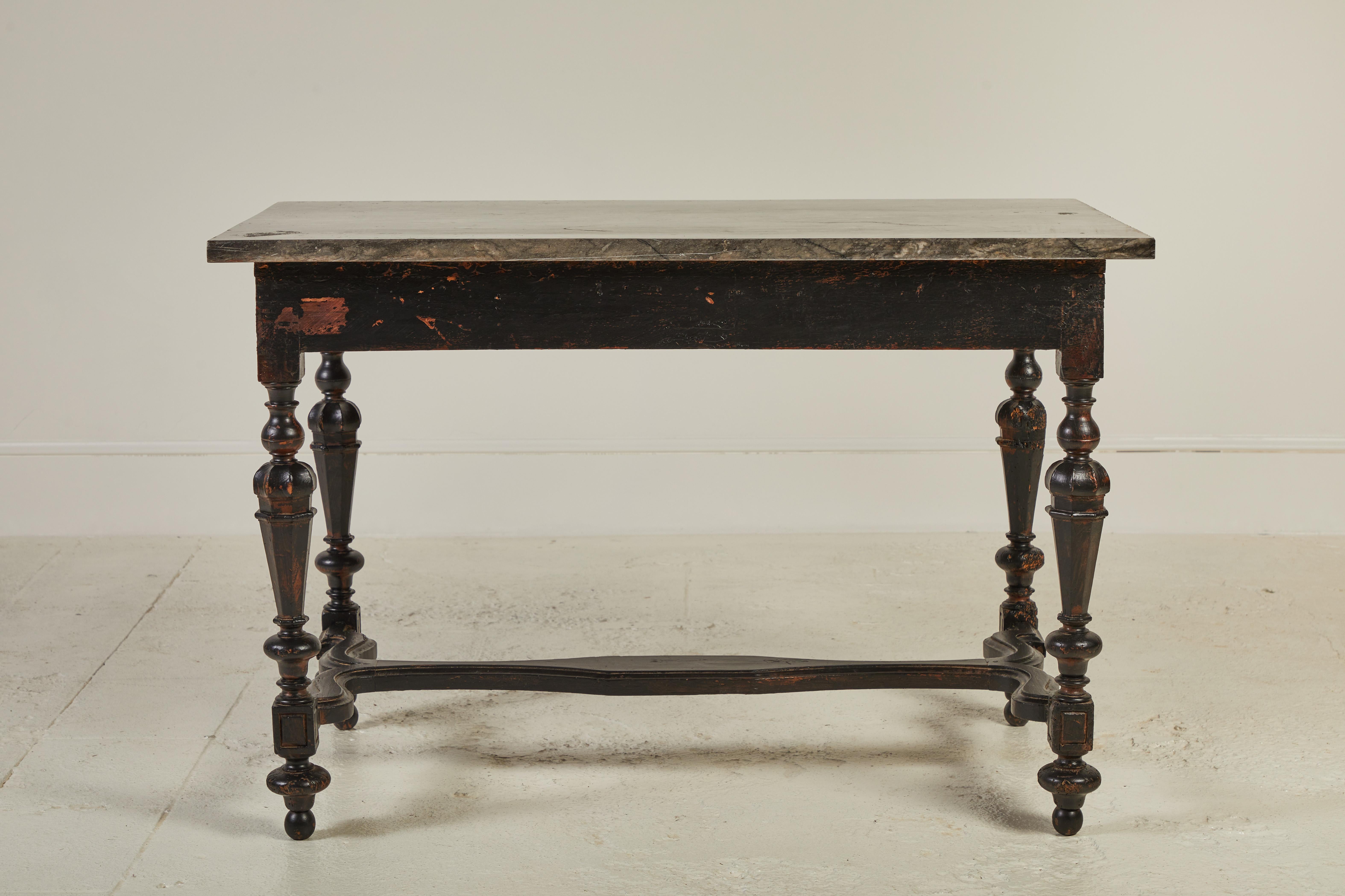 Elegant French black table with a detailed base with turned legs with an ornate stretcher base. A beautiful dark marble top finishes off the table.