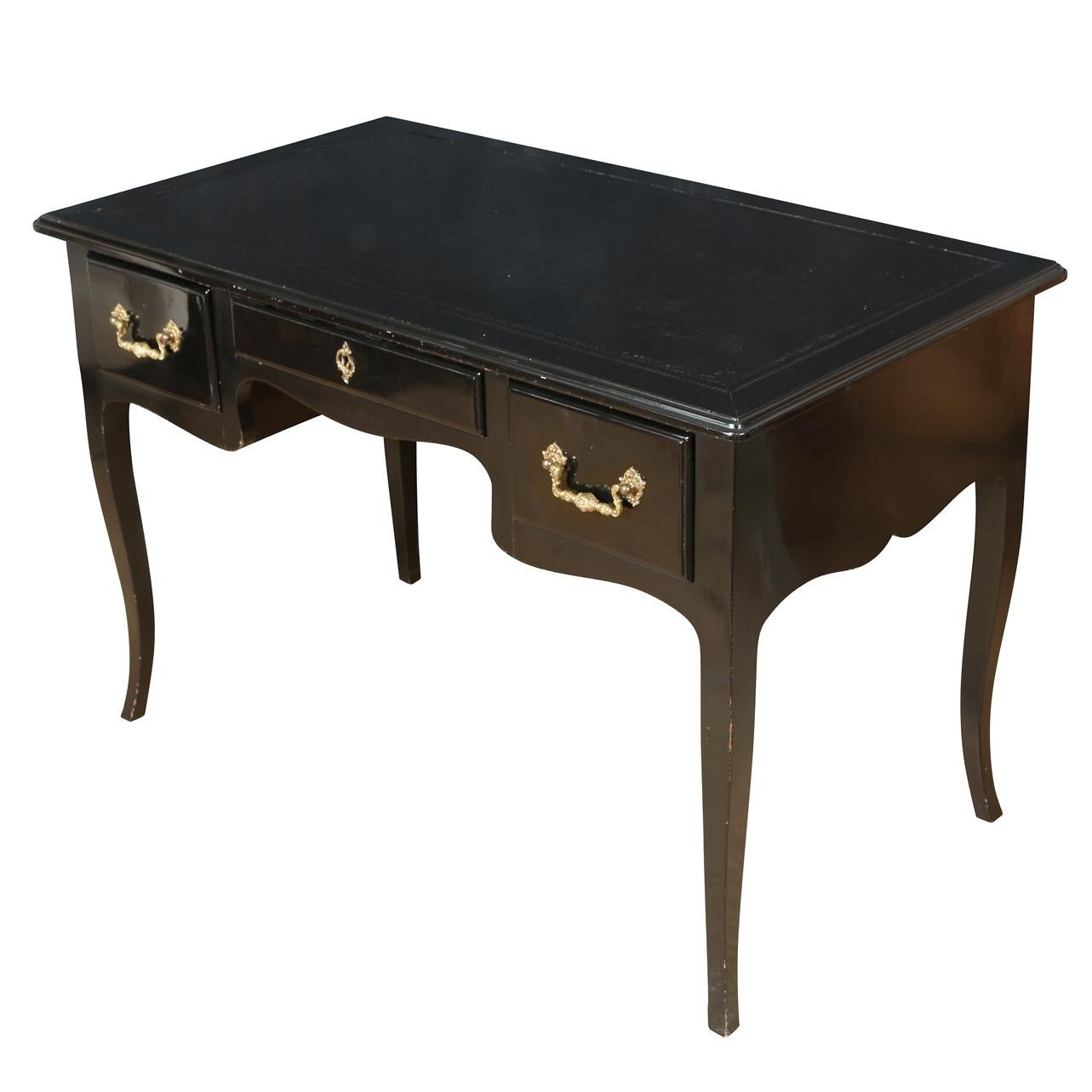 A black lacquer writing desk crafted in the French Louis XV style, embodying timeless elegance. Featuring three drawers, one on each side, adorned with detailed brass drawer pulls, this desk offers both functional storage and aesthetic appeal. Its