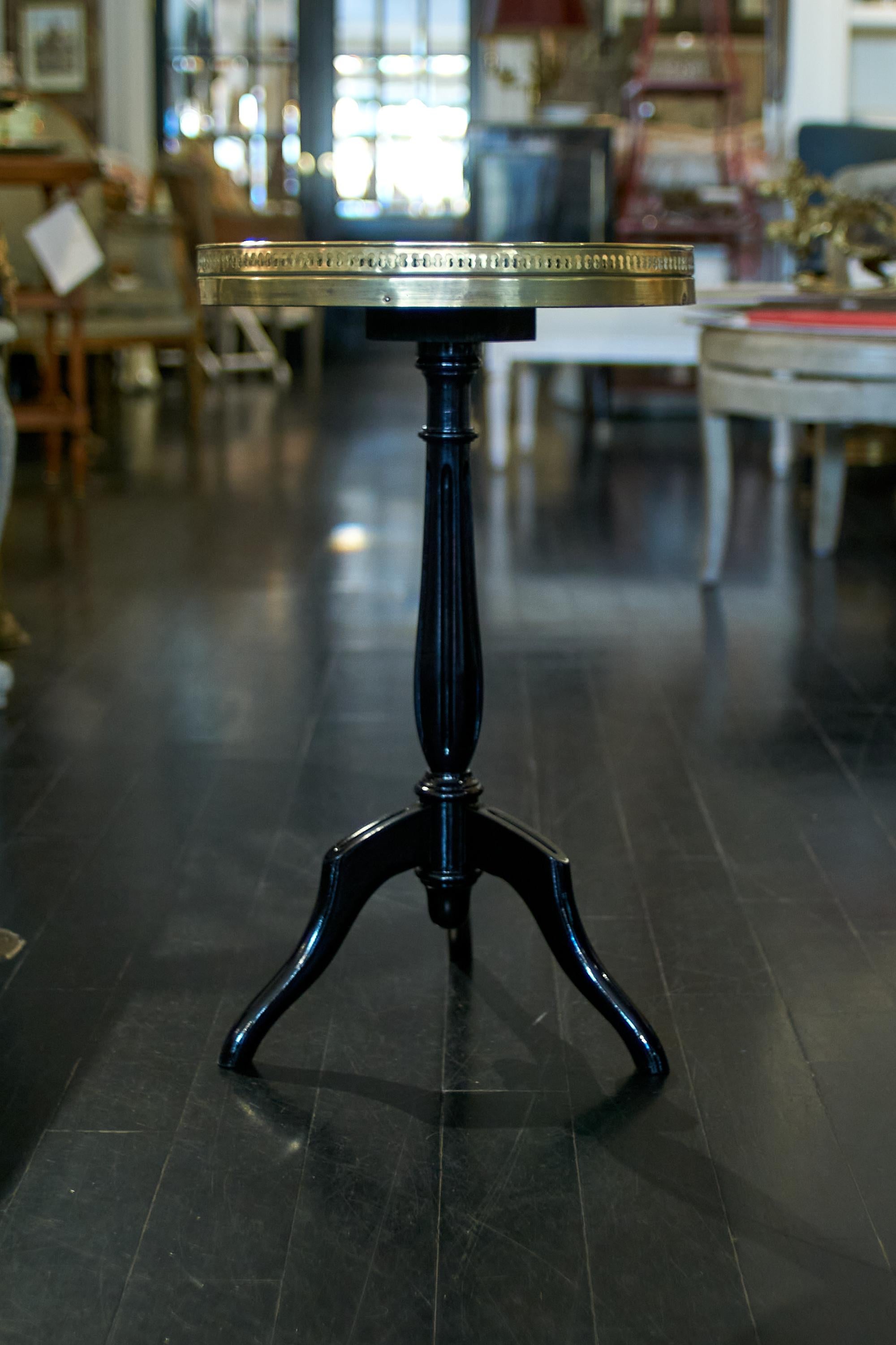 French black lacquered Guéridon, round marble top end table. These chic guéridons in the spirit of Maison Jansen are a staple of Mid-Century decorating. From the French homes of Hubert de GIvenchy to the fashionable appartments of New York, little