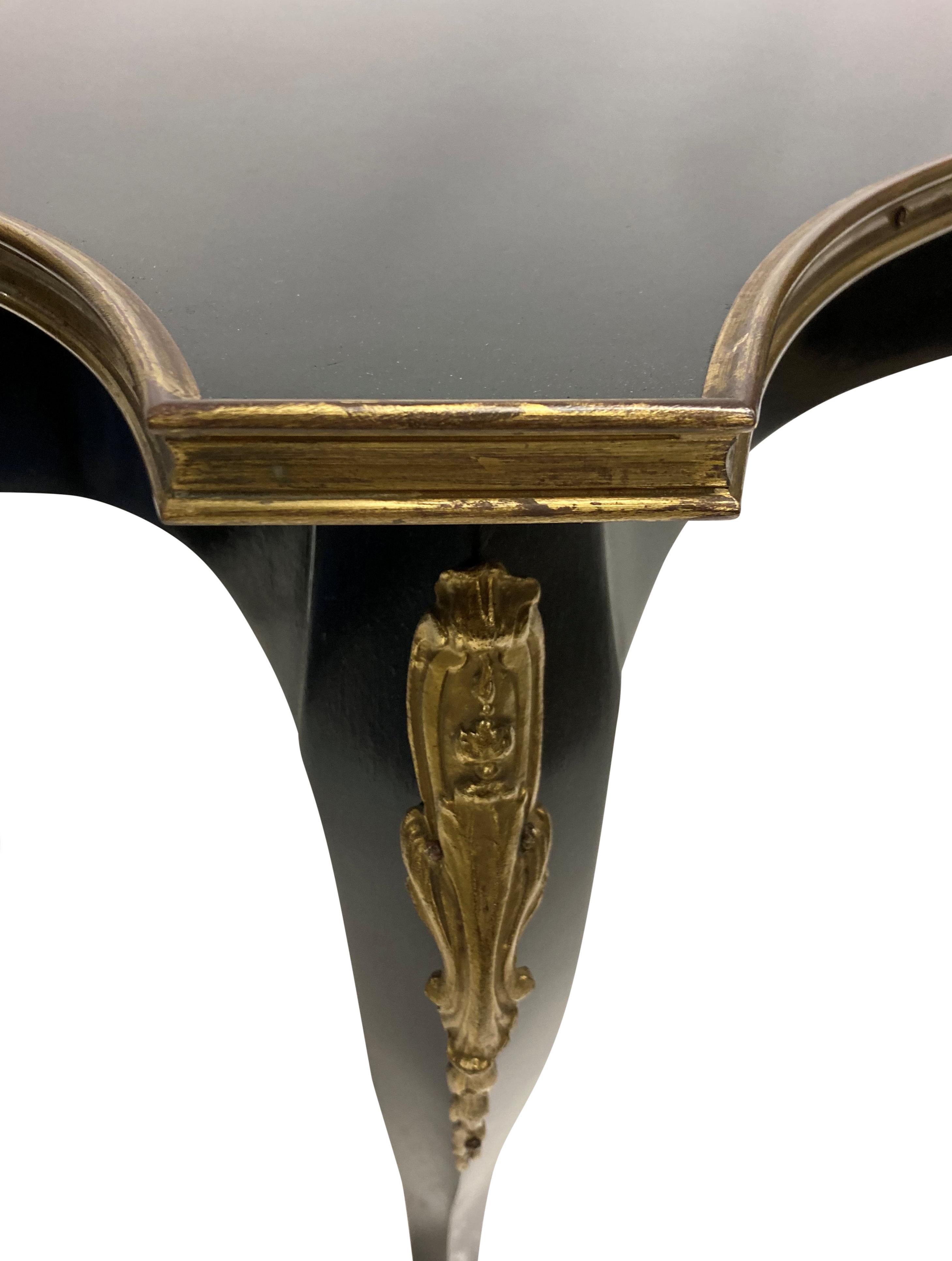 A French black lacquered Louis XV style occasional table with gilt bronze mounts and an inset glass top.