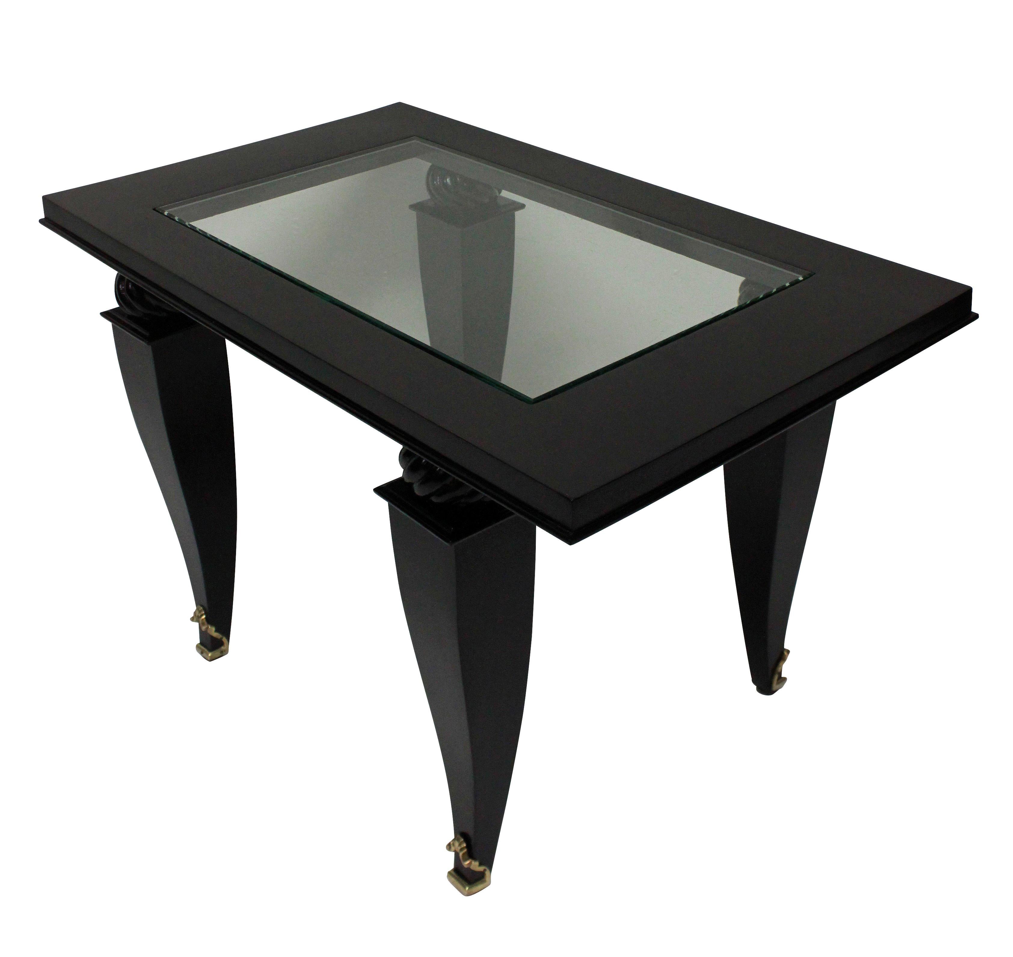 A French occasional table in black lacquer with a glass inset top and fine gilt bronze sabot feet.

 