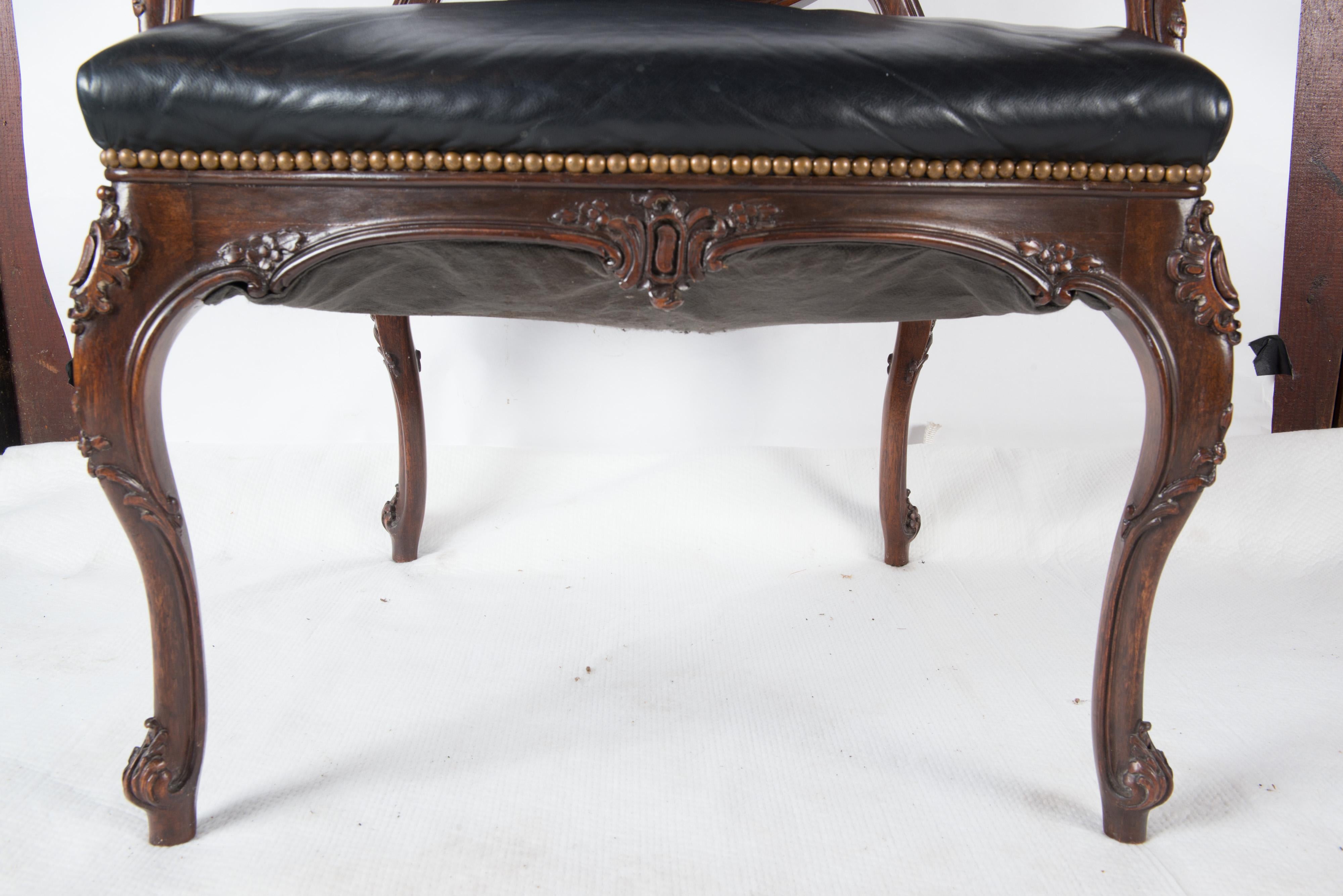 Fauteuil ou chaise de bureau de style Louis XV en noyer et cuir noir. La hauteur des bras est de 27 pouces.