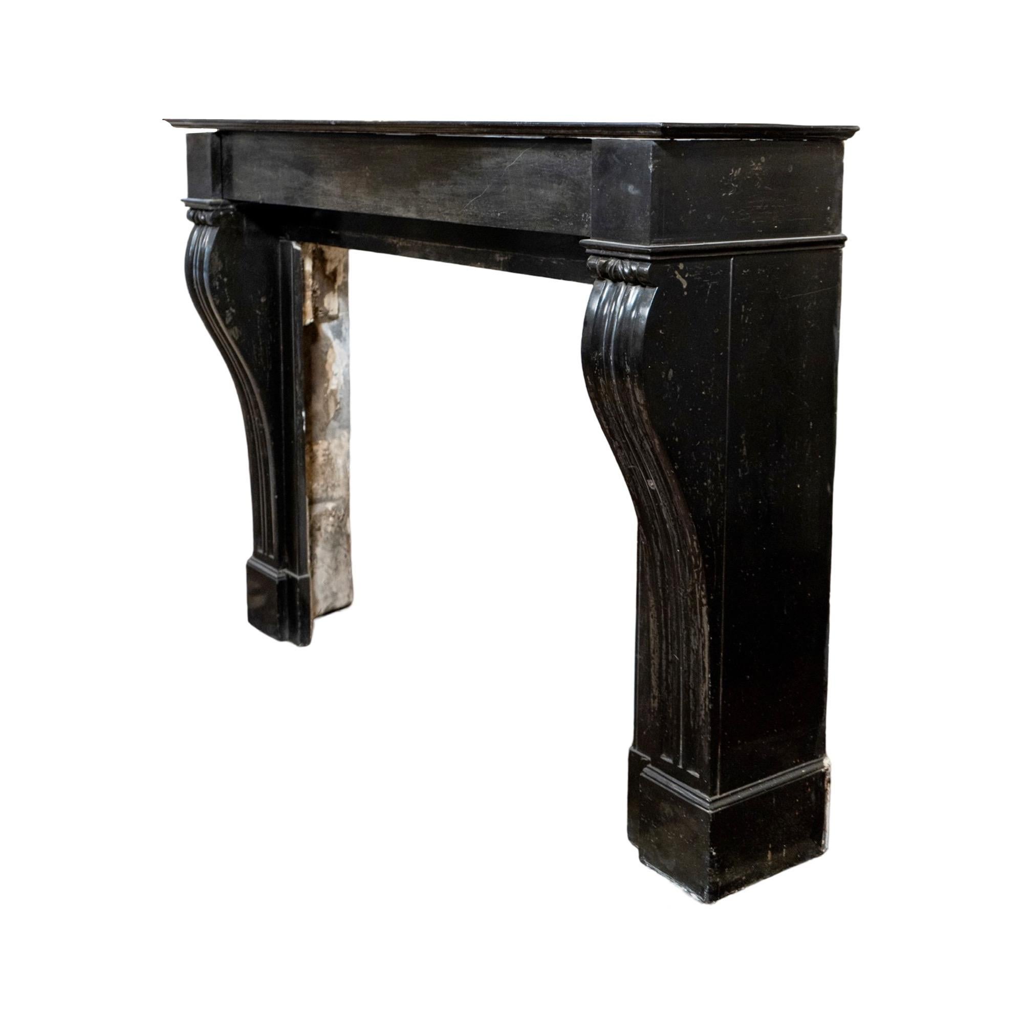 Una repisa de mármol antigua y recuperada, elaborada con mármol Mazy Black, importado de Francia y que data de la década de 1880. Esta pieza atemporal presenta un diseño acanalado de tres columnas en ambas patas, mostrando una artesanía impecable.