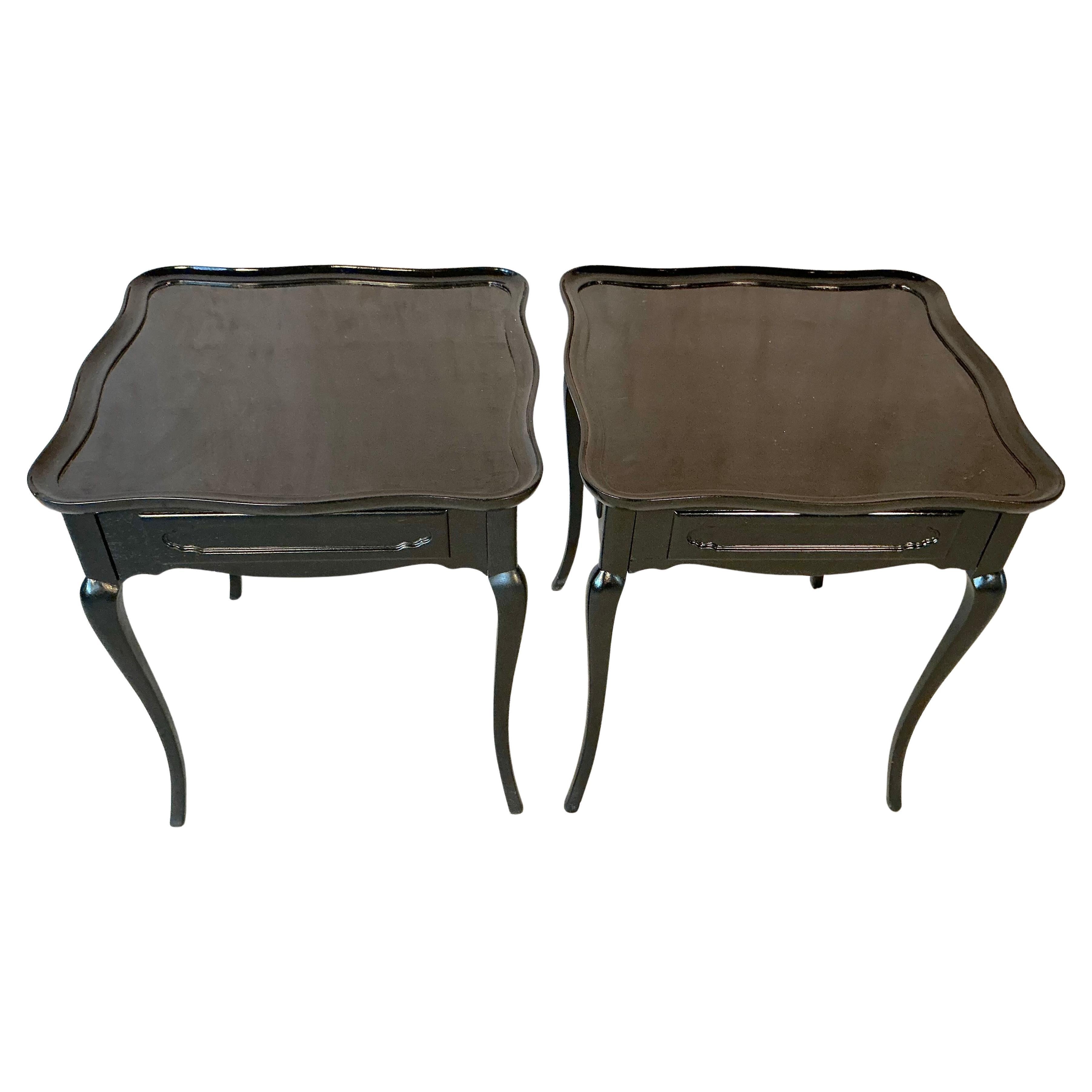 Elegante paire de tables d'appoint ou de chevet laquées noir. Chaque table comporte un seul tiroir subtilement sculpté et de gracieux pieds cabriole, surmontés d'un carré serpentin qui confère à la paire sa silhouette raffinée. Ces tables reprennent