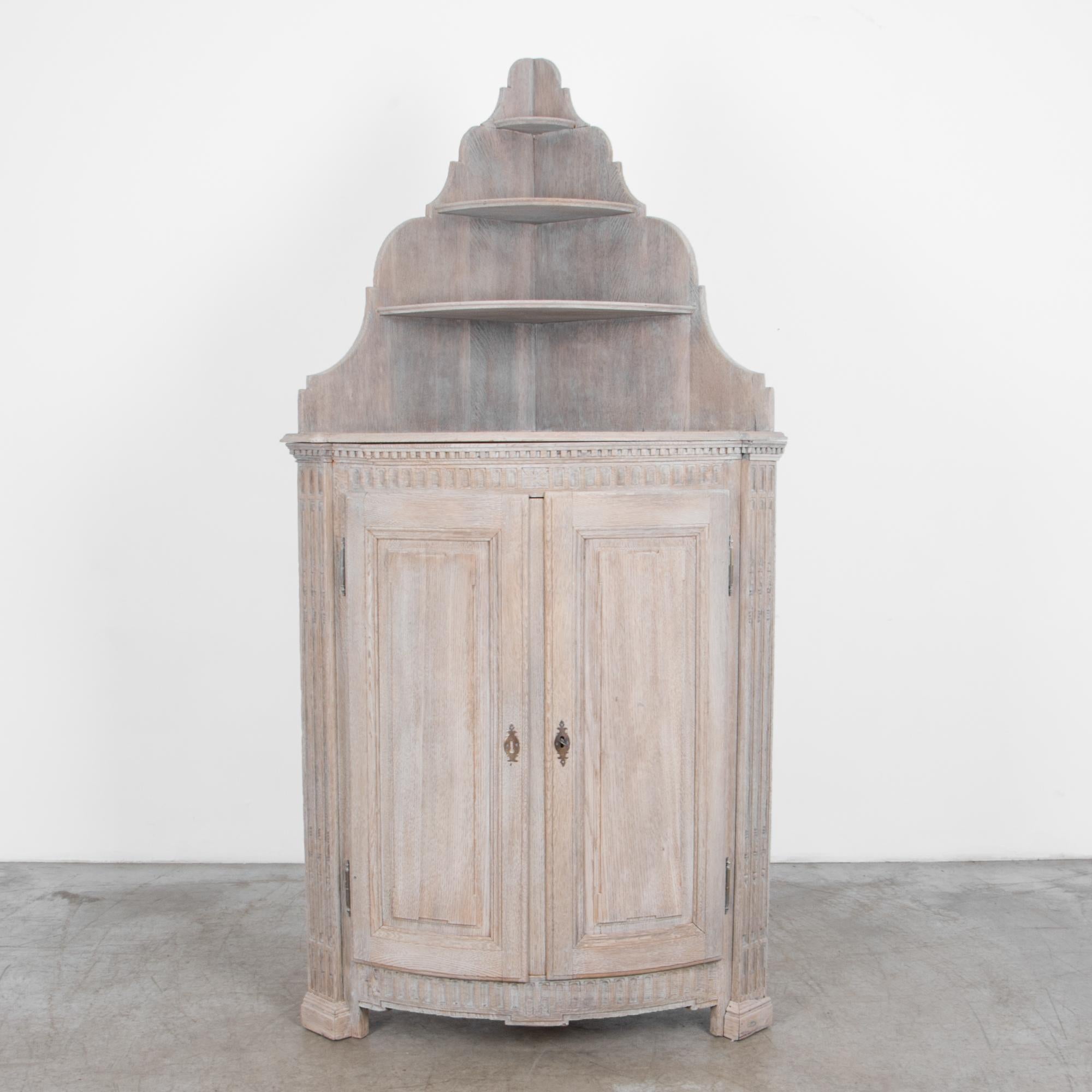 A Louis XVI style oak cabinet from circa 1820 France. Whitewashed with a subtle pigmented wax to enhance and rejuvenate the original finish, bringing out the texture of the wood grain. A driftwood look harmonises with the hand carved geometric