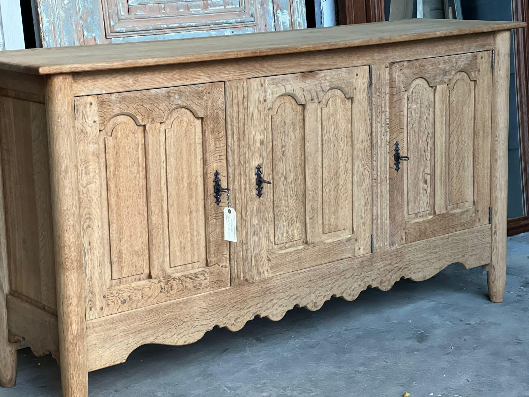 A stylish French sideboard, Enfilade or Dresser Base. Dating to the early 1900s and of excellent quality construction. Having 3 doors and 2 hidden internal drawers. Made from solid Oak which we have bleached to bring out the beauty of the wood. 
In