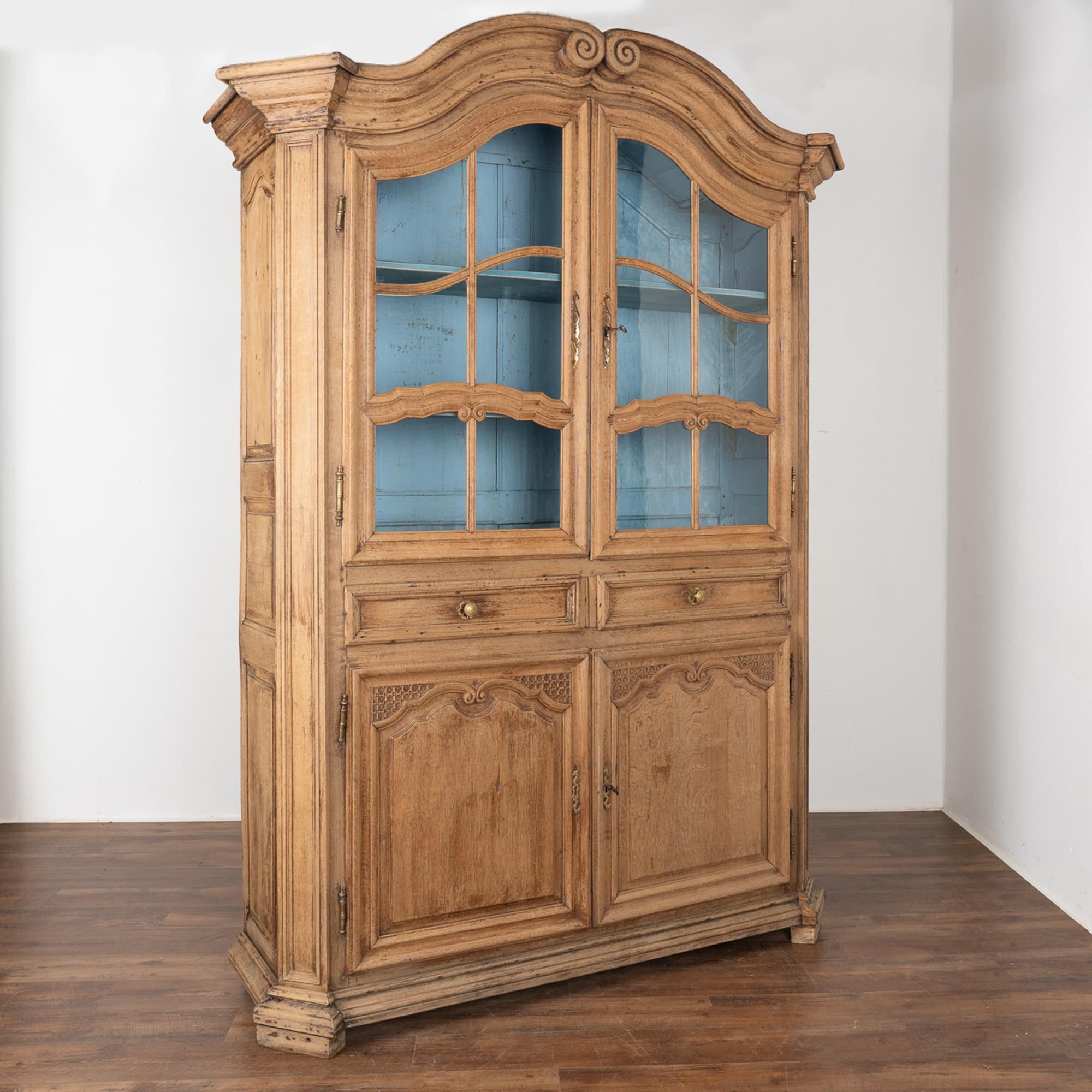 The traditional scrolled and arched crown is captivating in this French vitrine. The oak has been bleached, giving it a fresh look for today's modern home while bringing in the charm of French country craftsmanship.
Carved, scrolled accents bring