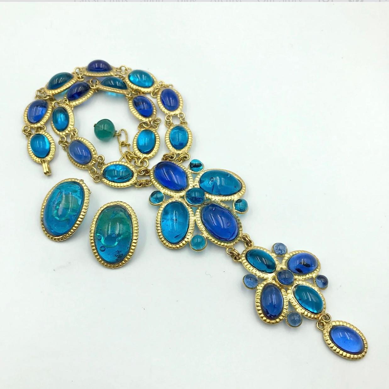 A magnificent vintage Gripoix, Pate de Verre, Glass Necklace and Earring Set.

A single row of oval gilt metal frames, set with alternating electric blue and turquoise clear Gripoix glass cabochons, supports an articulated three tier pendant, also
