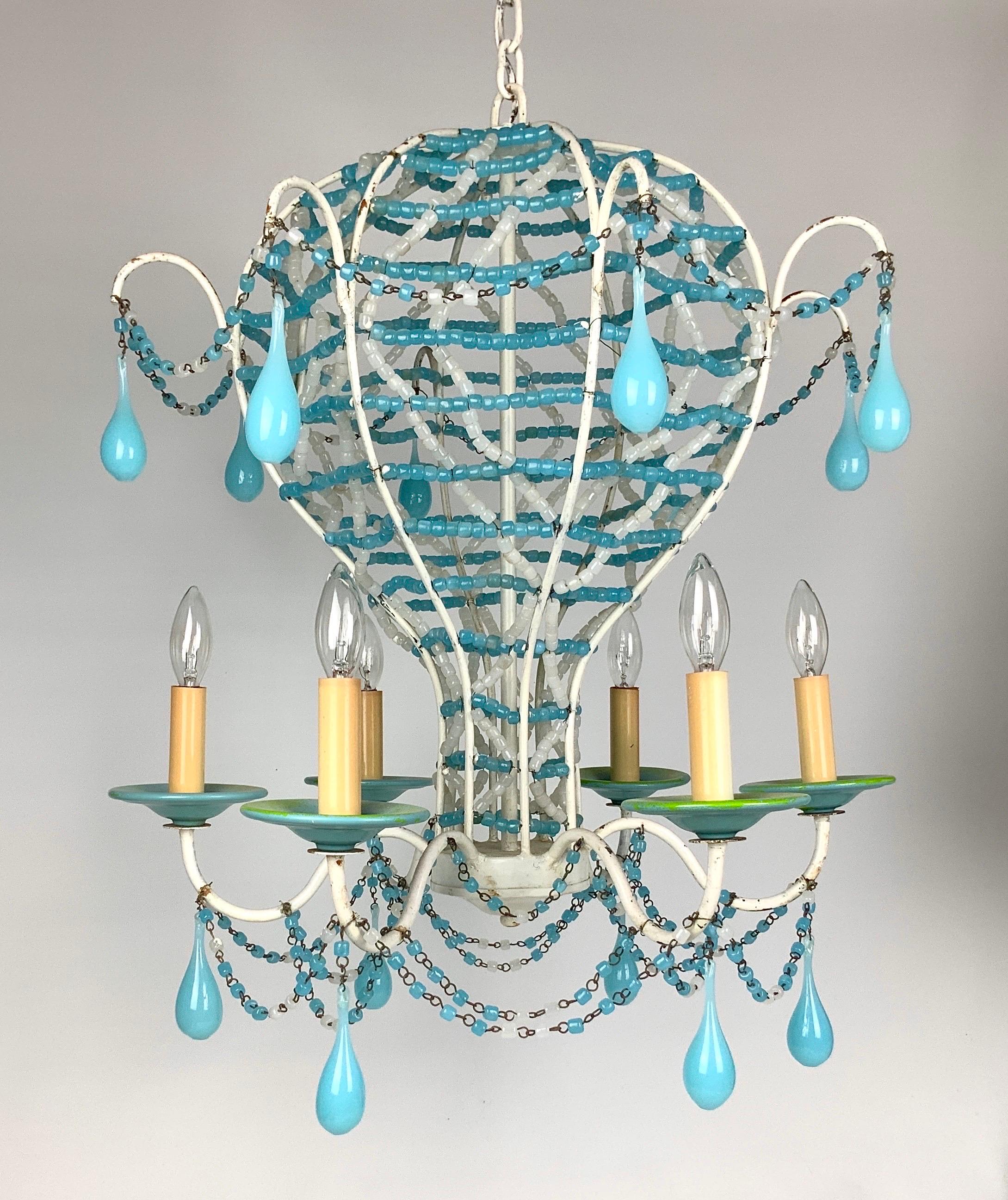 A fantastic vintage blue and white opaline beaded French hot air balloon chandelier covered in opaline beads. This two tier chandelier dripping with large blue opaline prisms, features six sockets. Certainly a statement piece in any foyer, dining