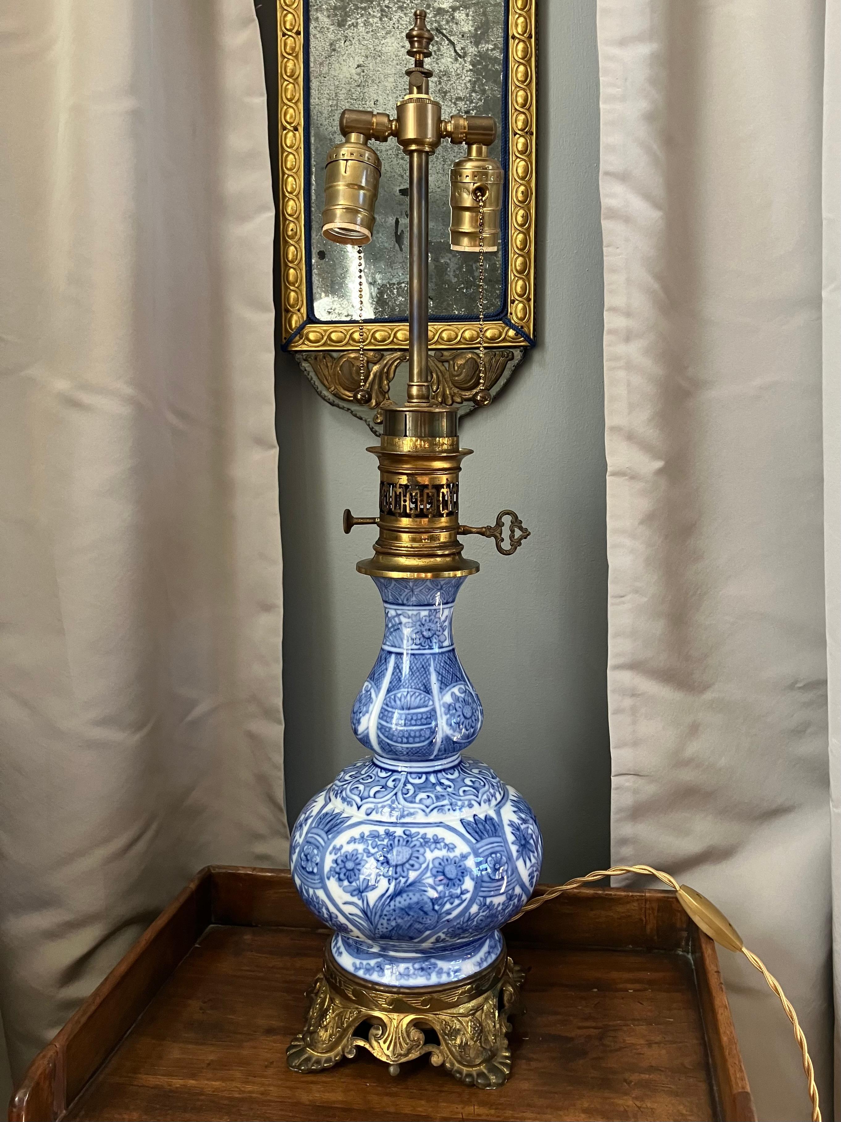 Lampada a balaustro in porcellana francese bianca e blu  Strepitoso vaso a balaustro in ceramica floreale blu e bianca montato come lampada a gas con base in ottone dorato decorata a fiori e collare a galleria forato con accessori originali per
