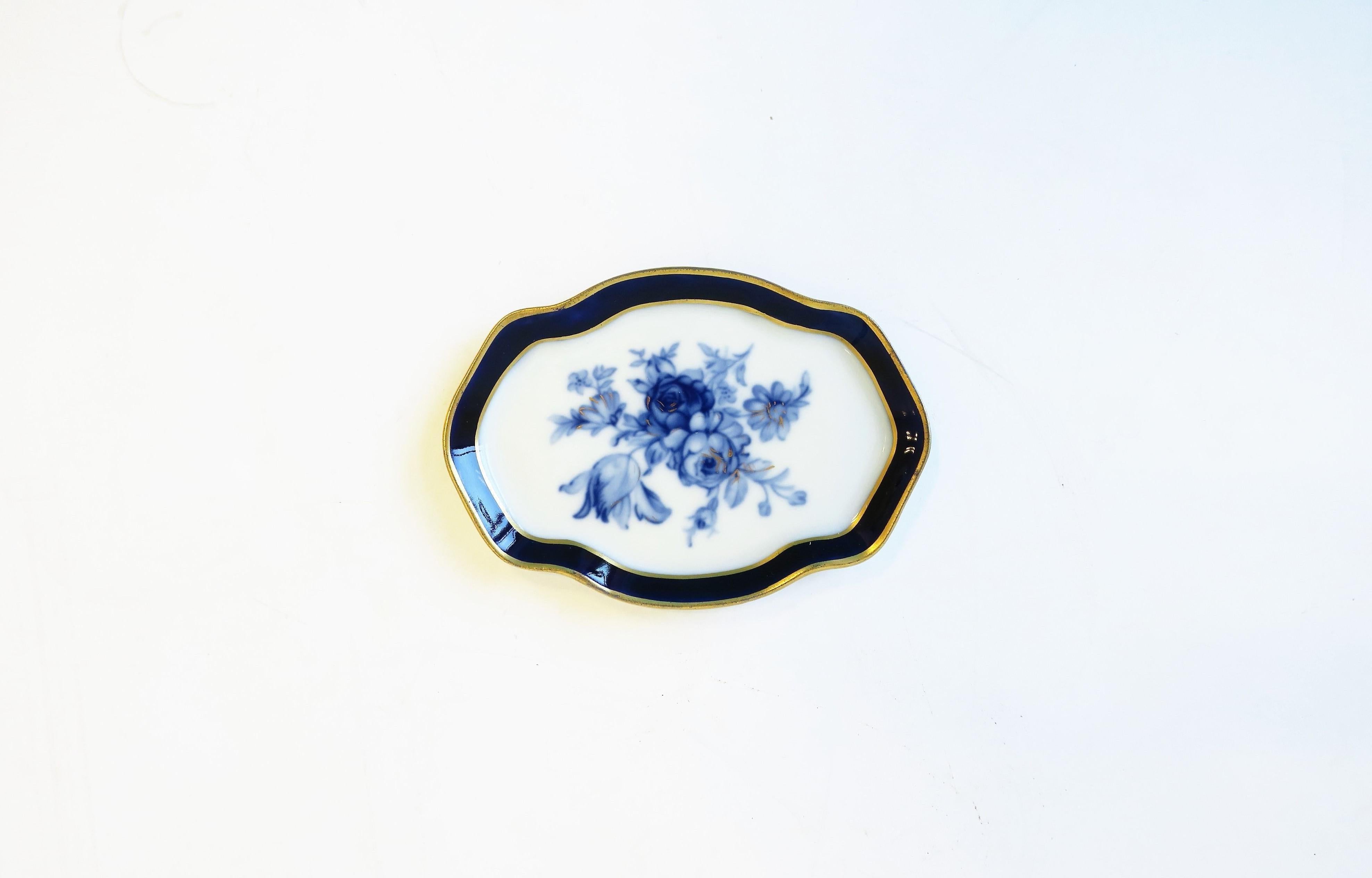 A beautiful French blue and white porcelain jewelry dish in the Rococo style, circa early 20th century, Limoges, France. Piece has a floral 'chintz' design of light and dark blue flowers and touches of gold. Piece is oval with decorative indents,