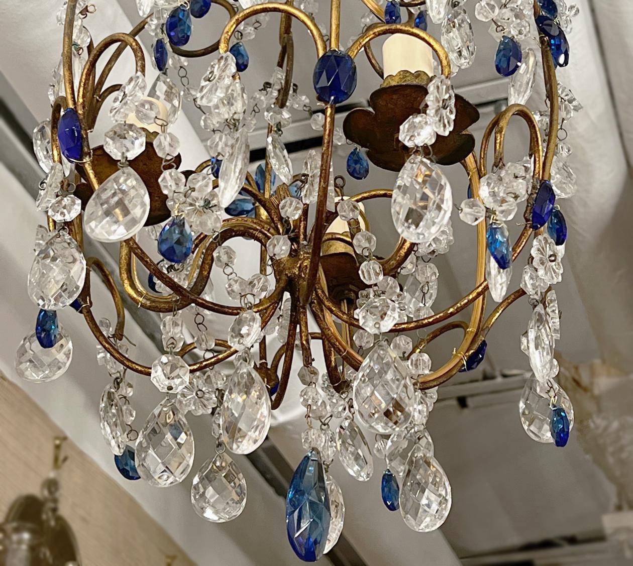 A circa 1950s gilt metal chandelier with blue beads and 3 lights.

Measurements:
Minimum drop: 24