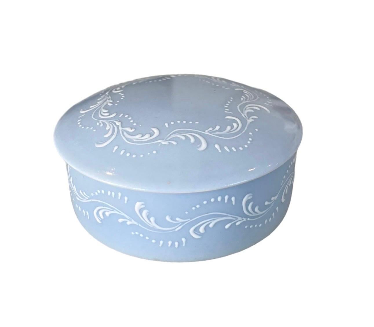 Très jolie petite boîte, bonbonnière en porcelaine de Limoges, création de la Maison Baud Paris.
La couleur bleue est très délicate, dans un ton pastel, et les motifs de feuillage blanc gaufrés et peints à la main sont très délicats.
L'ensemble est