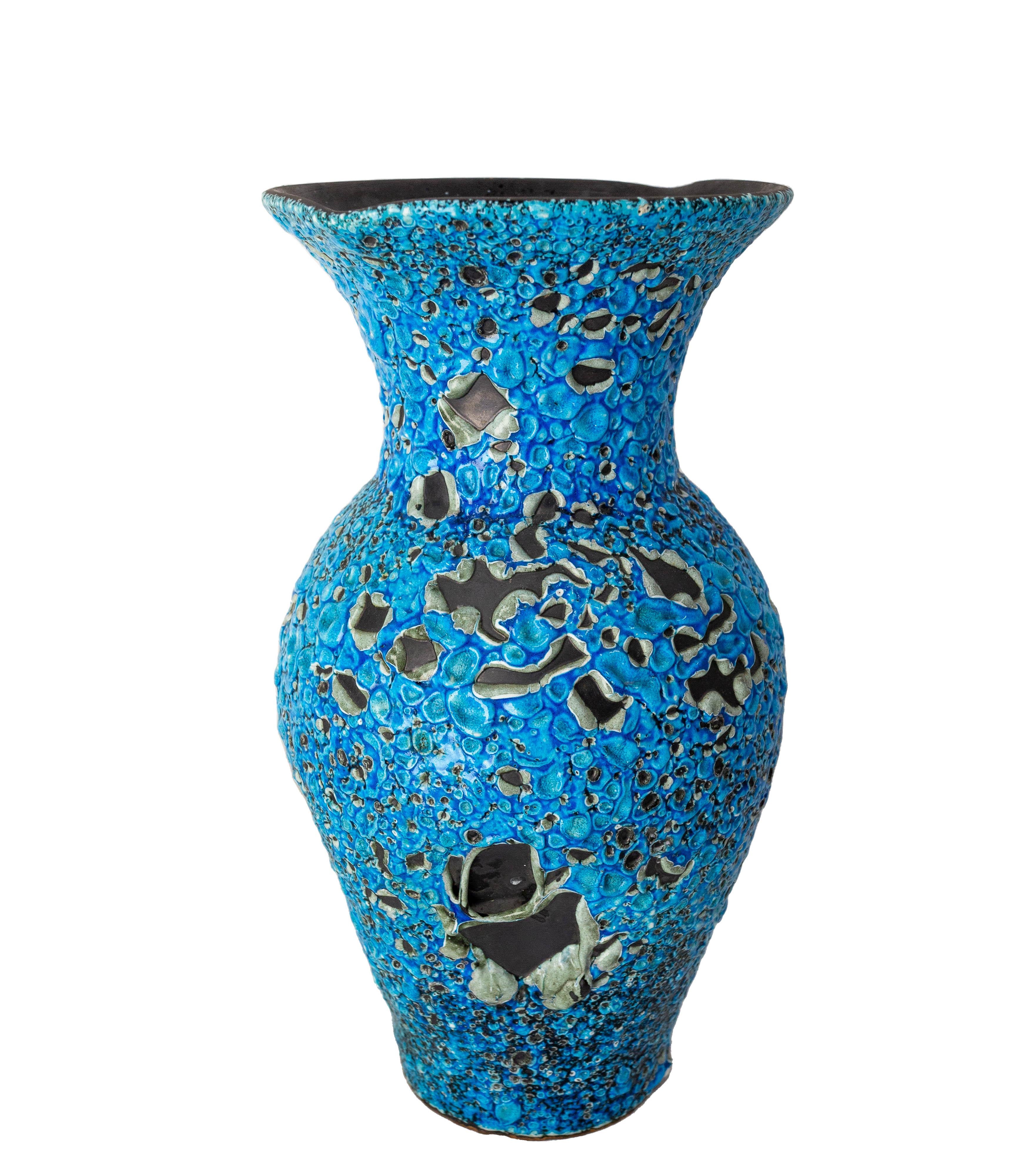 This blue vase was produced in France by Charles Cart.
He called it Cyclope because of the large volcanic dimples created during the firing of the pottery which reveal the layers of white and black below the surface. Charles Cart registered the