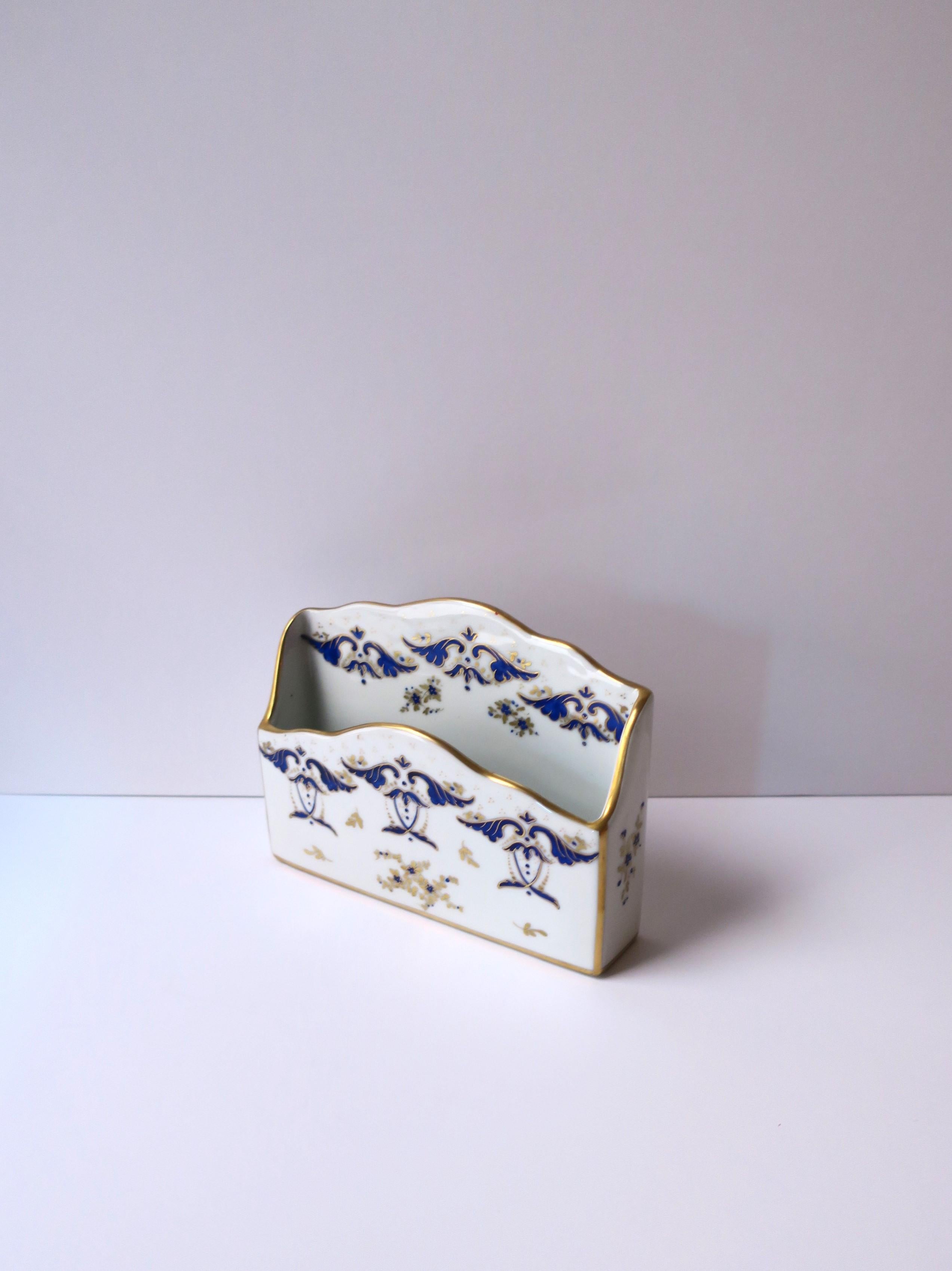 A French white porcelain desk letter or mail holder with small flowers and leaves in the Rococo design style, circa mid-20th century, Paris, France. Piece with scalloped edge is hand-painted in blue and gold hues on front, sides and back, with