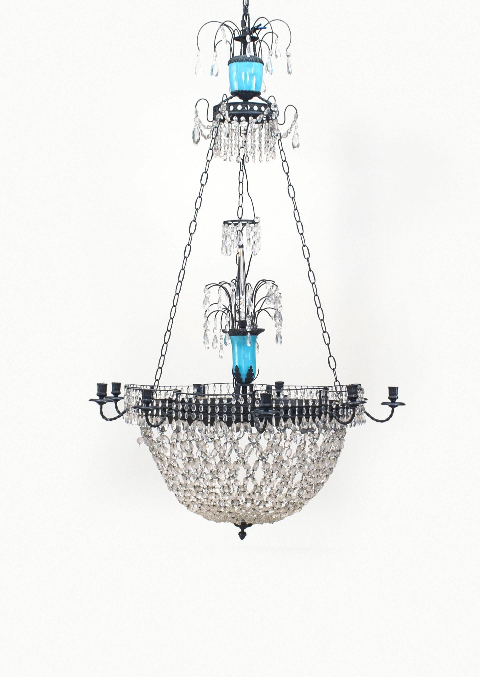 Nineteenth century French chandelier featuring a segmented opaline glass stem above a round, bowl-shaped crystal bottom rimmed with nine candleholder arms and culminating in an iron finial.