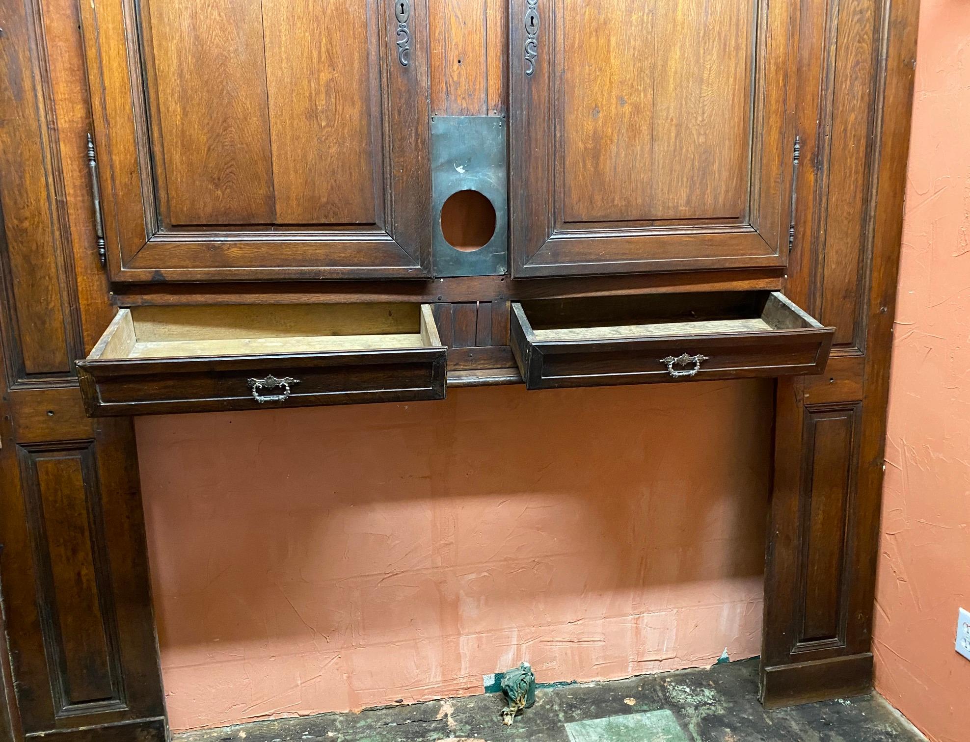 Bellissima boiserie da parete proveniente da un castello di campagna francese. L'antica parete a pannelli in rovere del XIX secolo Directorie è composta da una porta d'ingresso e da una coppia di porte doppie sopra 2 cassetti, una mensola stretta