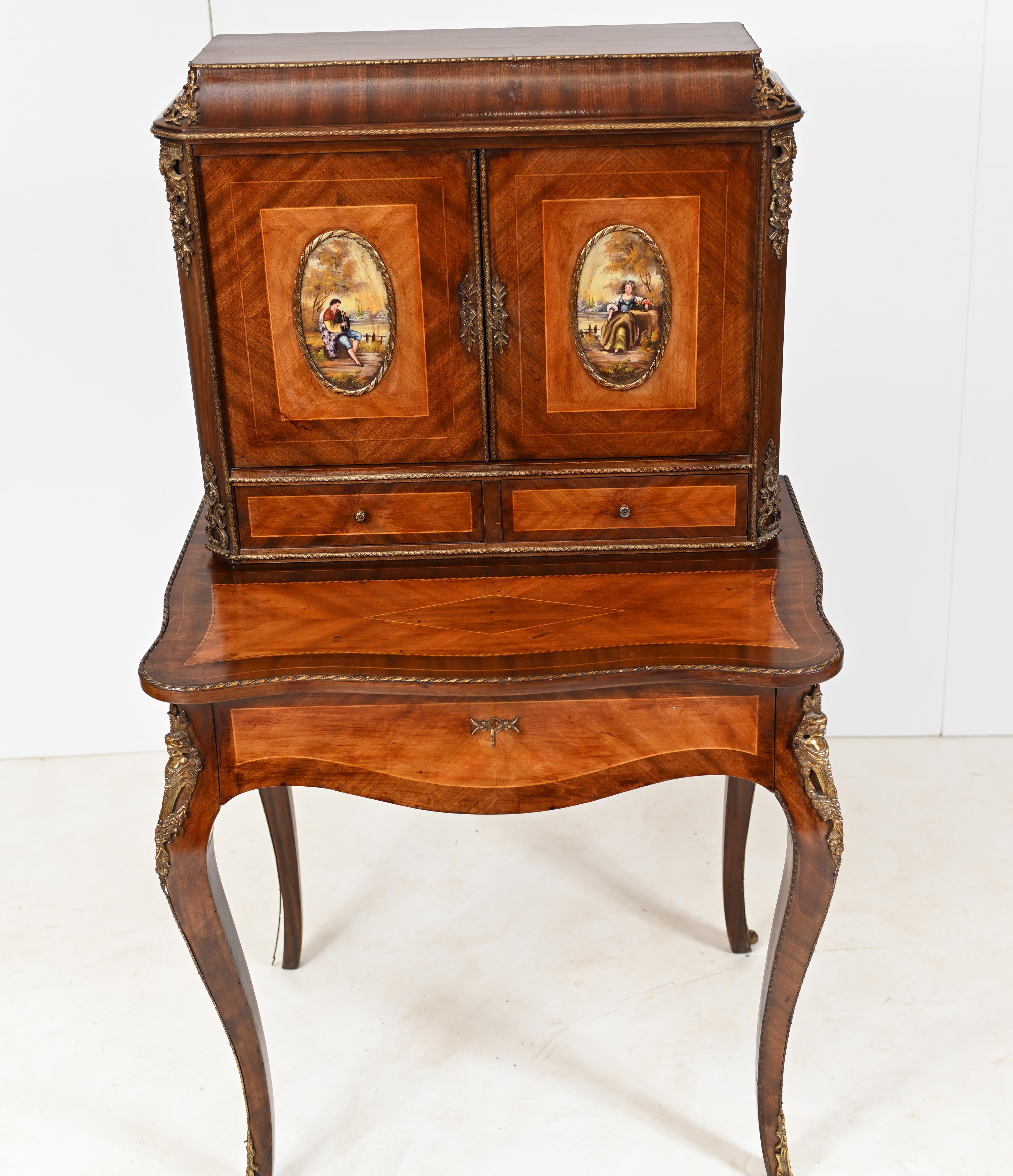 Stunning French Bonheur de Jour desk we date to circa 1920
Crafted from kingwood with painted plaques showing scenes of courtly love with two romantic couples
Top is a cabinet with drawers when opened out
Top drawer opens out to reveal green