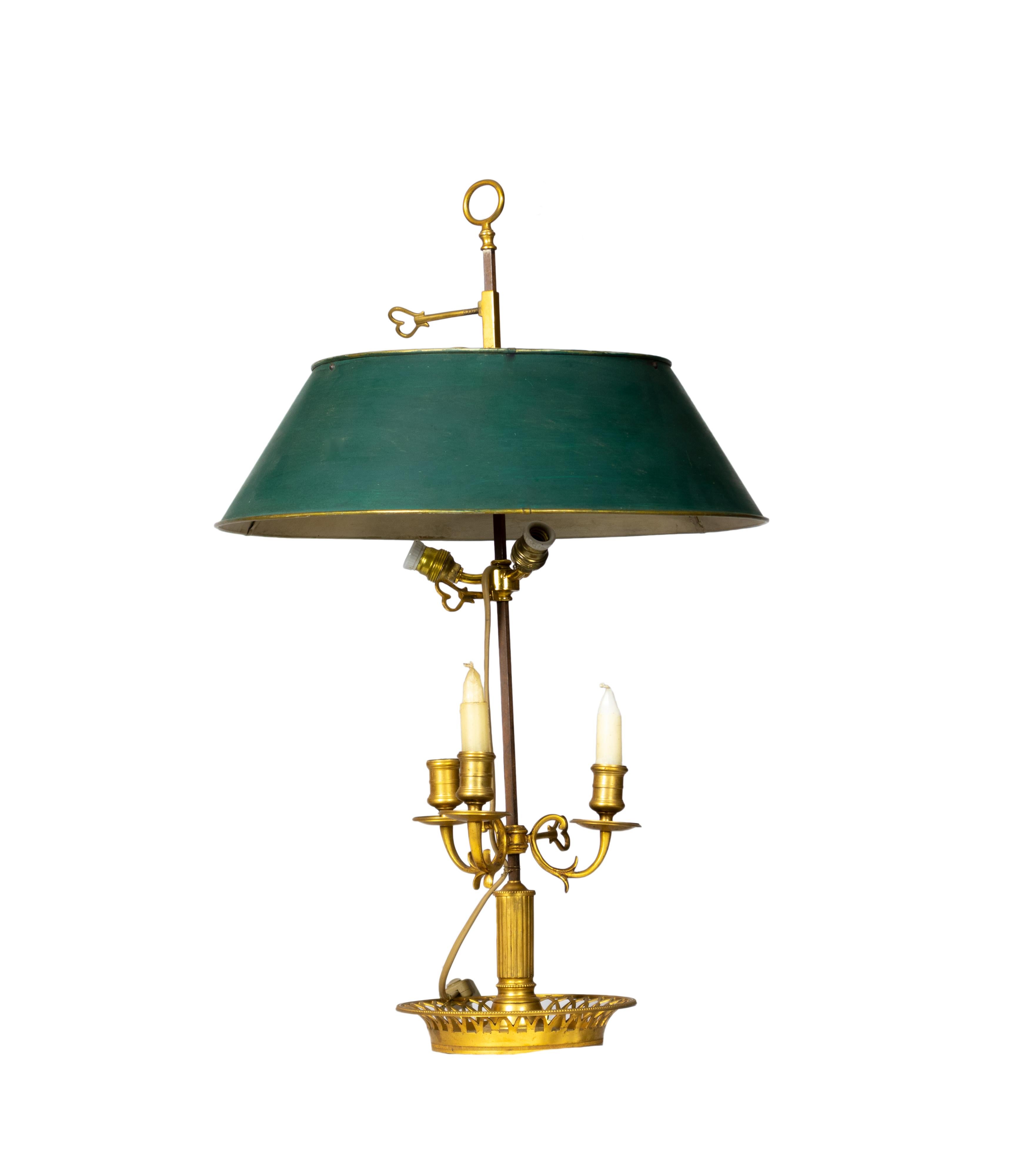 Eine Bouillotte-Lampe im französischen Empire-Stil mit drei bronzenen Leuchten und einem verstellbaren Schirm wird durch einen grünen Tole-Schirm in Grüntönen ergänzt.
