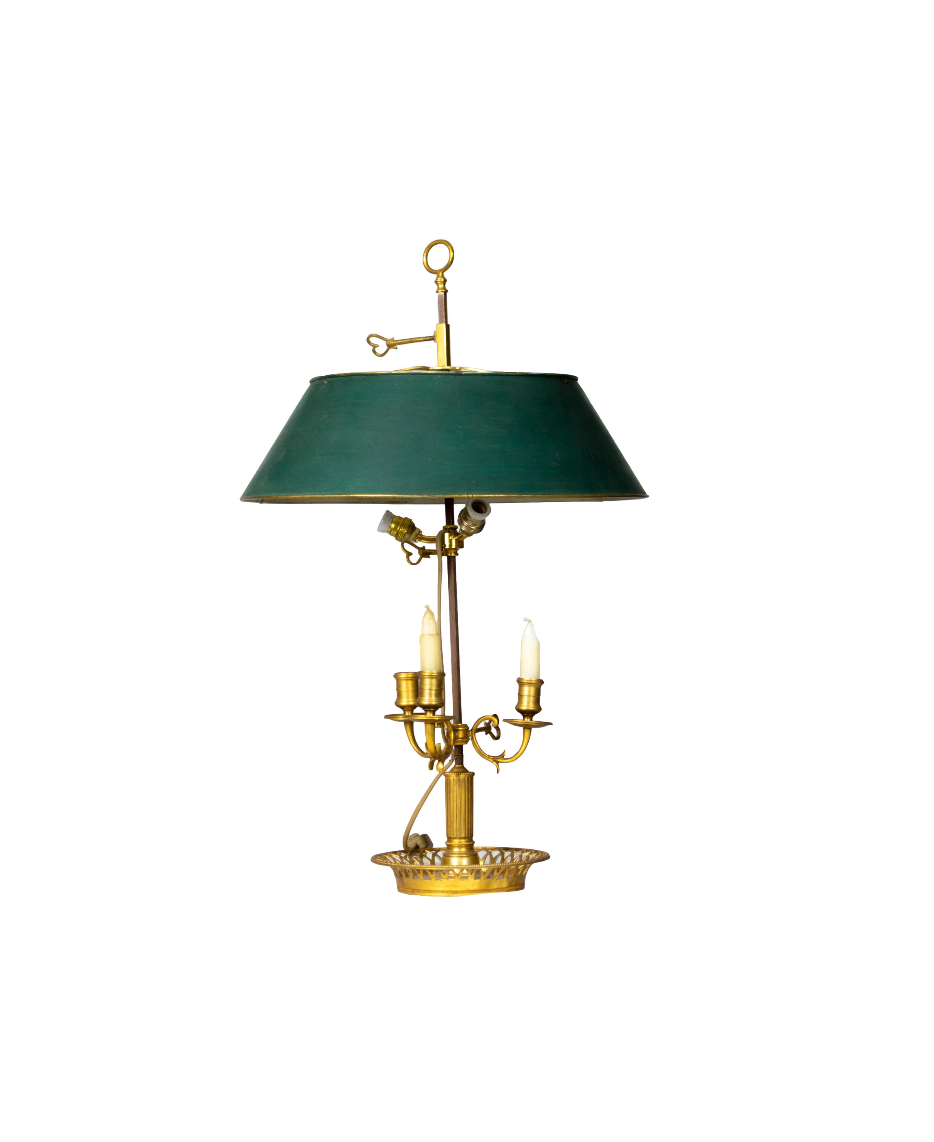 Une lampe bouillotte d'époque de style Empire français, dotée de trois lampes en bronze et d'un écran réglable, est complétée par un abat-jour en tole verdoyant dans les tons de vert.
