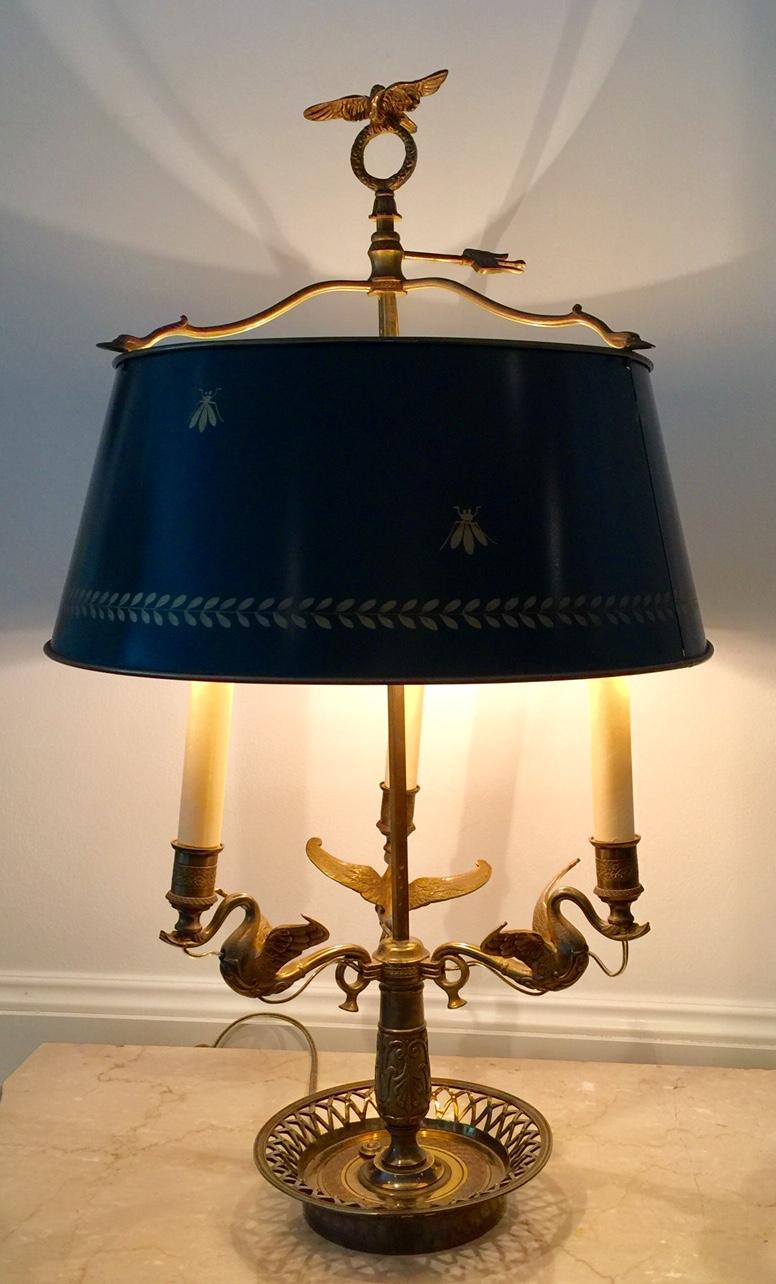 French Bouillotte lamp, Bee and Laurel leaf decorations in gilt, painted green tôle shade.
Empire style. Three arm lamp in the shape of swans with open-weave basket base. Finial a bronze eagle atop a bronze Laurel leaf crown. Adjustable tôle shade