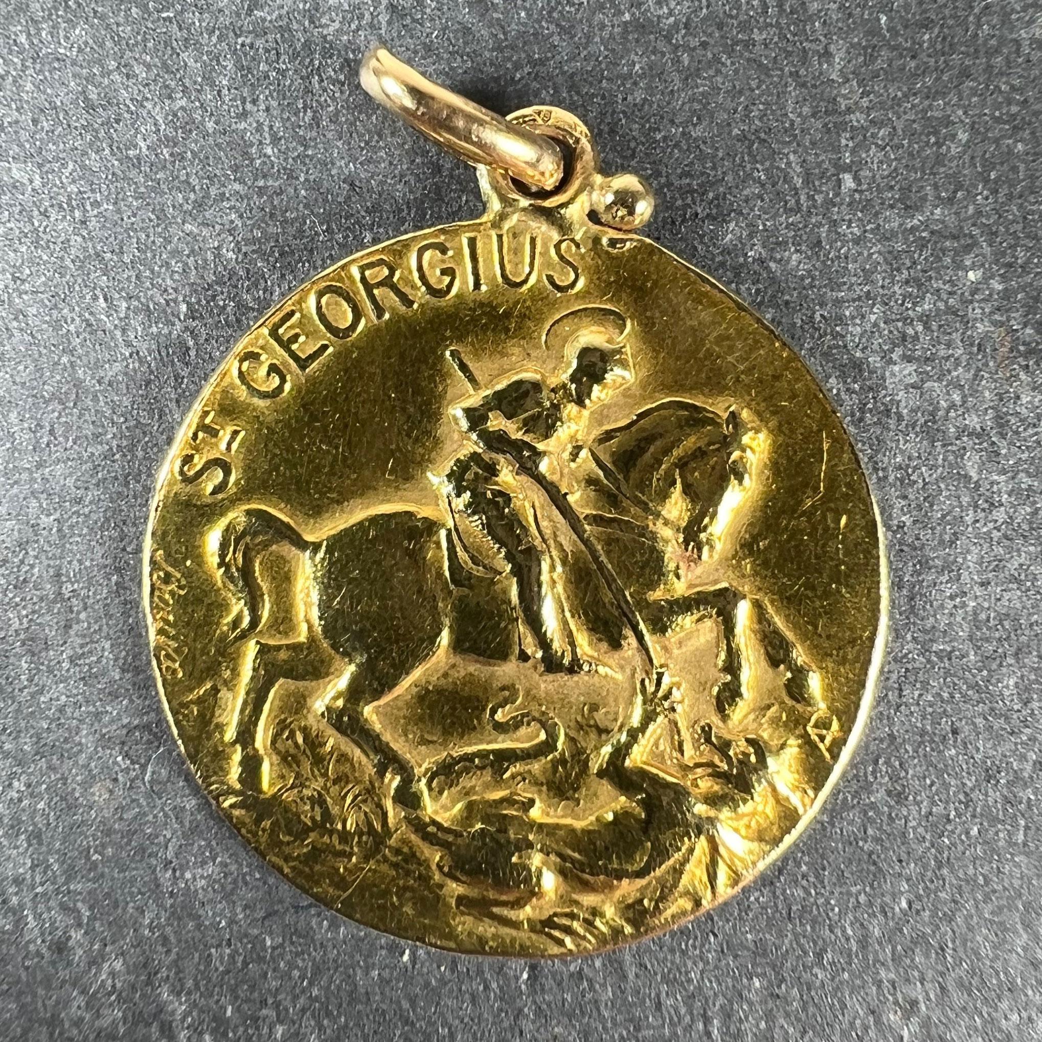 Pendentif à breloques en or jaune 18 carats (18K) français conçu comme une médaille représentant Saint Georges sur un cheval cabré terrassant le dragon. La phrase de St Georgius écrite ci-dessus. Signé Bouix. Le revers représente un navire dans une