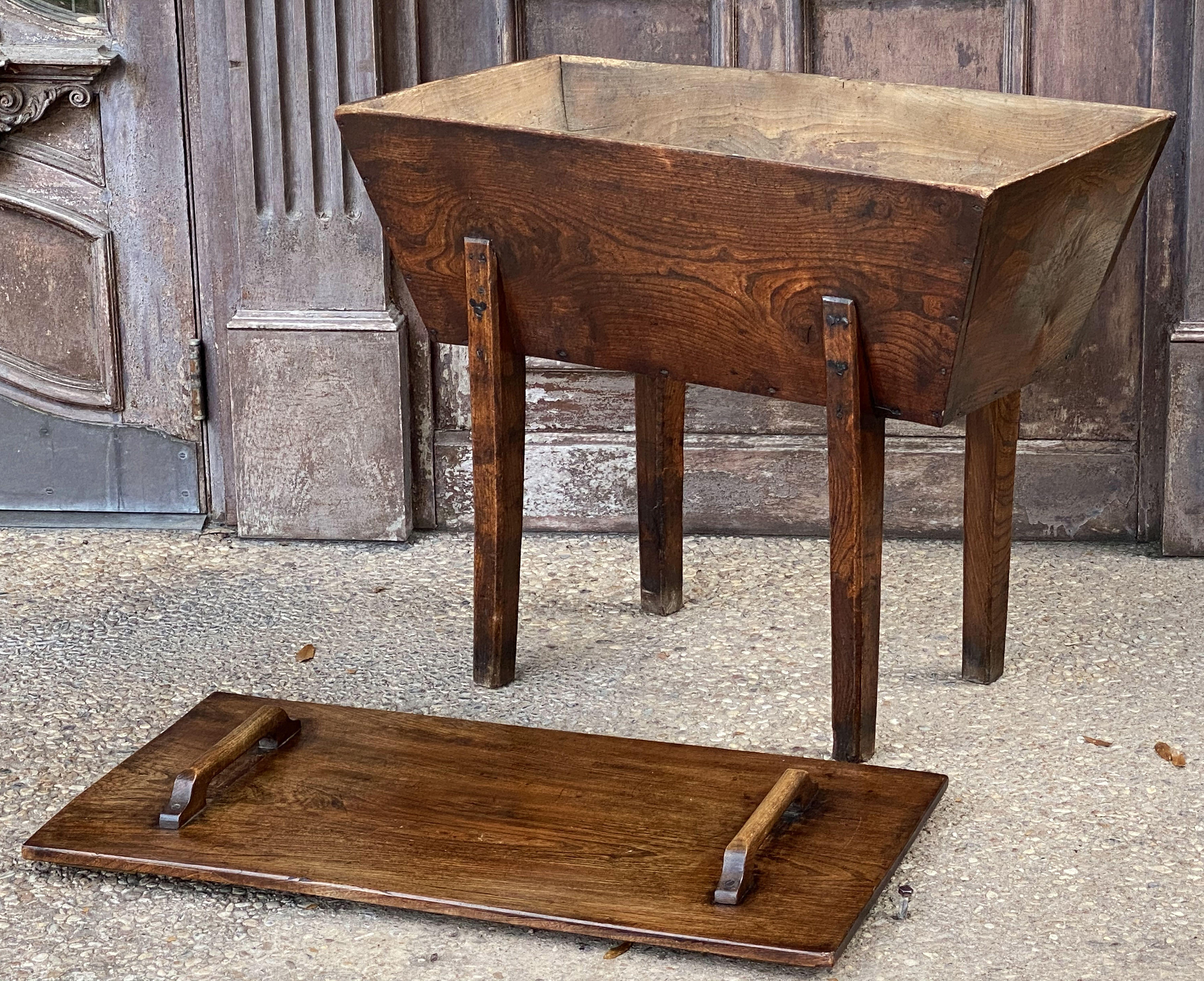 A fine French dough bin or proving chest of elm from a 19th century boulangerie or bakery, with a handsome patina, removable rectangular lid with handles, over a rustic base, resting on four tapering legs.

The interior of the bin was where flour