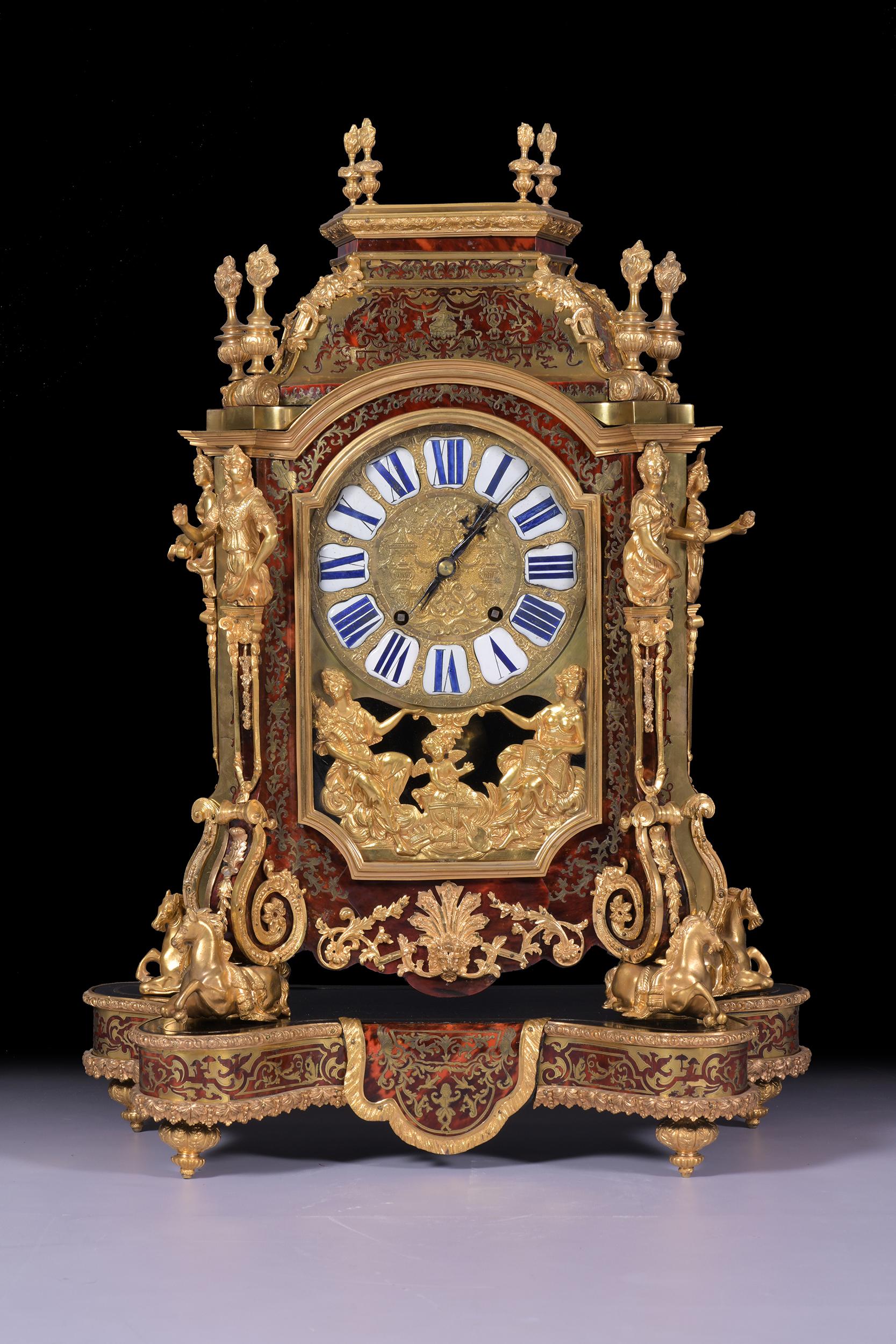 An exceptional 19th century French ormolu-mounted, boulle and cut brass-inlaid mantel clock In the Regence style, after André-Charles Boulle. The stepped pediment surmounted by four small and four larger flaming vase finials, the domed pediment with