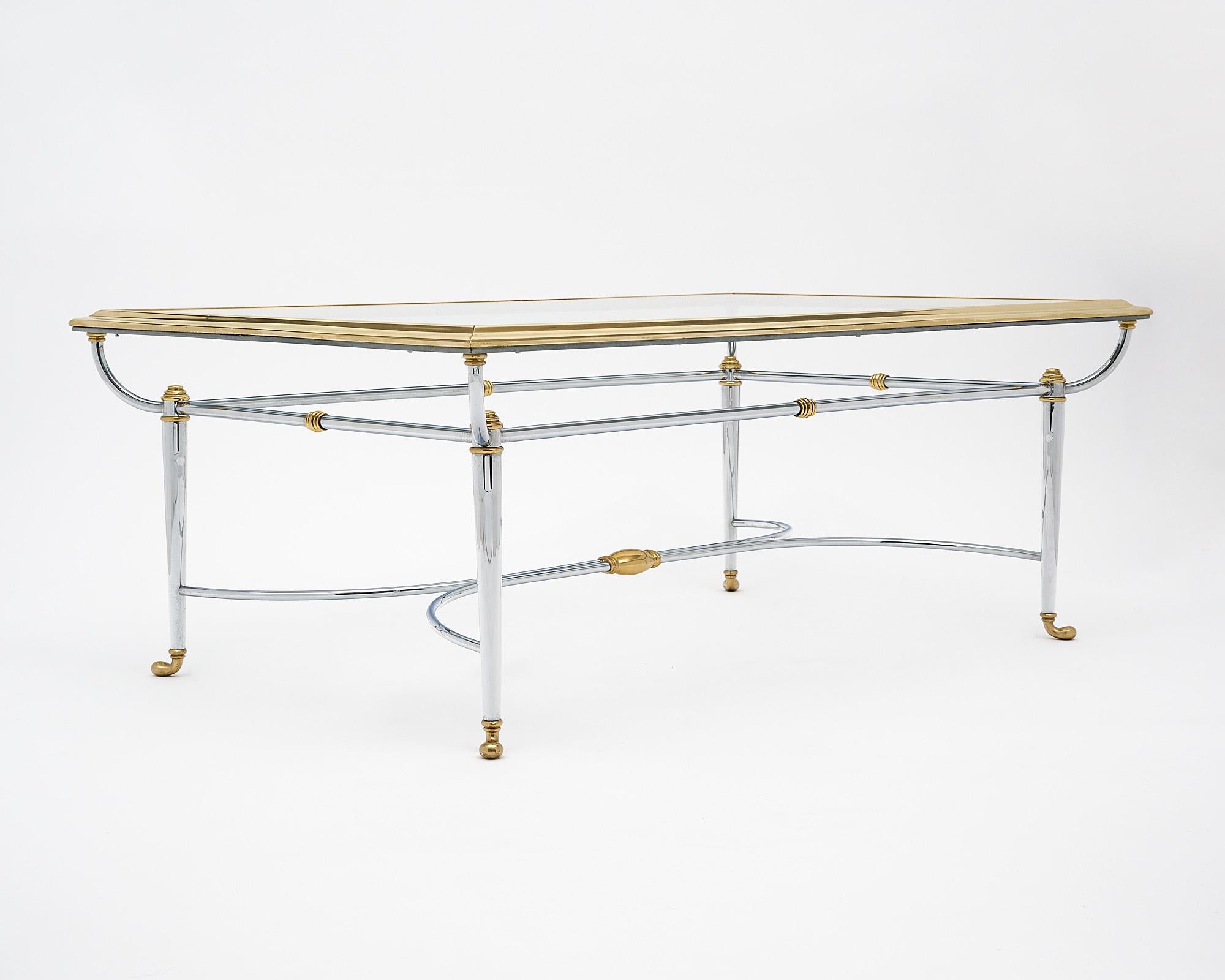 Coffee table, French, made of chromed steel and brass crafted by mid-century iconic Parisian firm “Maison Charles”. It is topped with a shelf of clear glass.