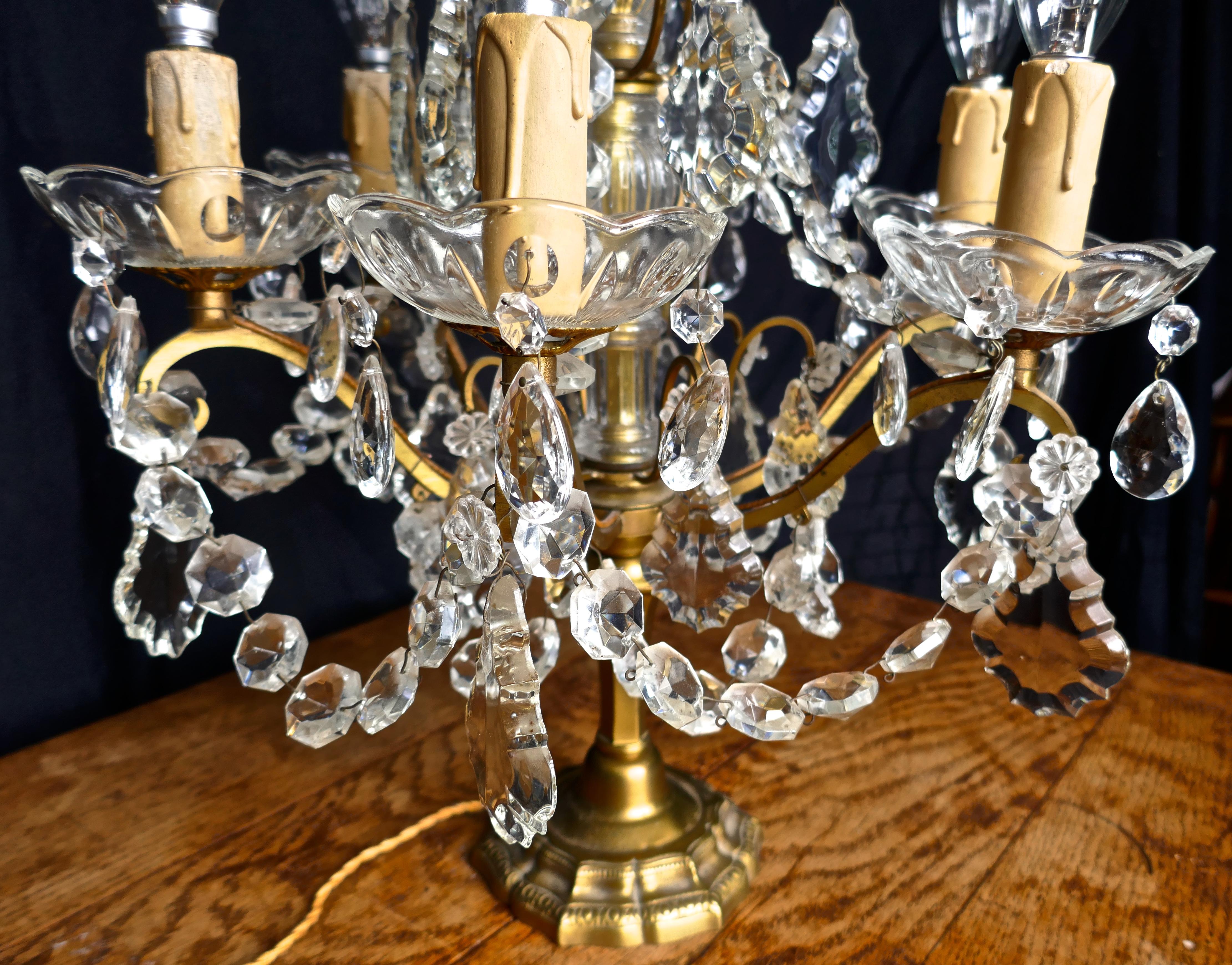 French brass and crystal 6 branch chandelier table lamp, Girandole

This is a very rare and stunningly attractive piece, the lamp has a decorative brass base with a glass covered upright central column supporting a superb brass and crystal lustre