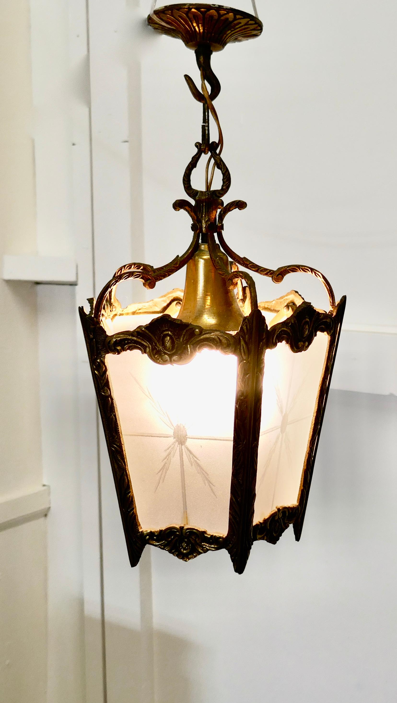 French brass and etched glass lantern hall light

A superb quality heavy brass lantern, the light has 5 glass panels, these are etched with a starburst

The lantern is decorated in the French style with ribbons and leaves and it hangs on a brass