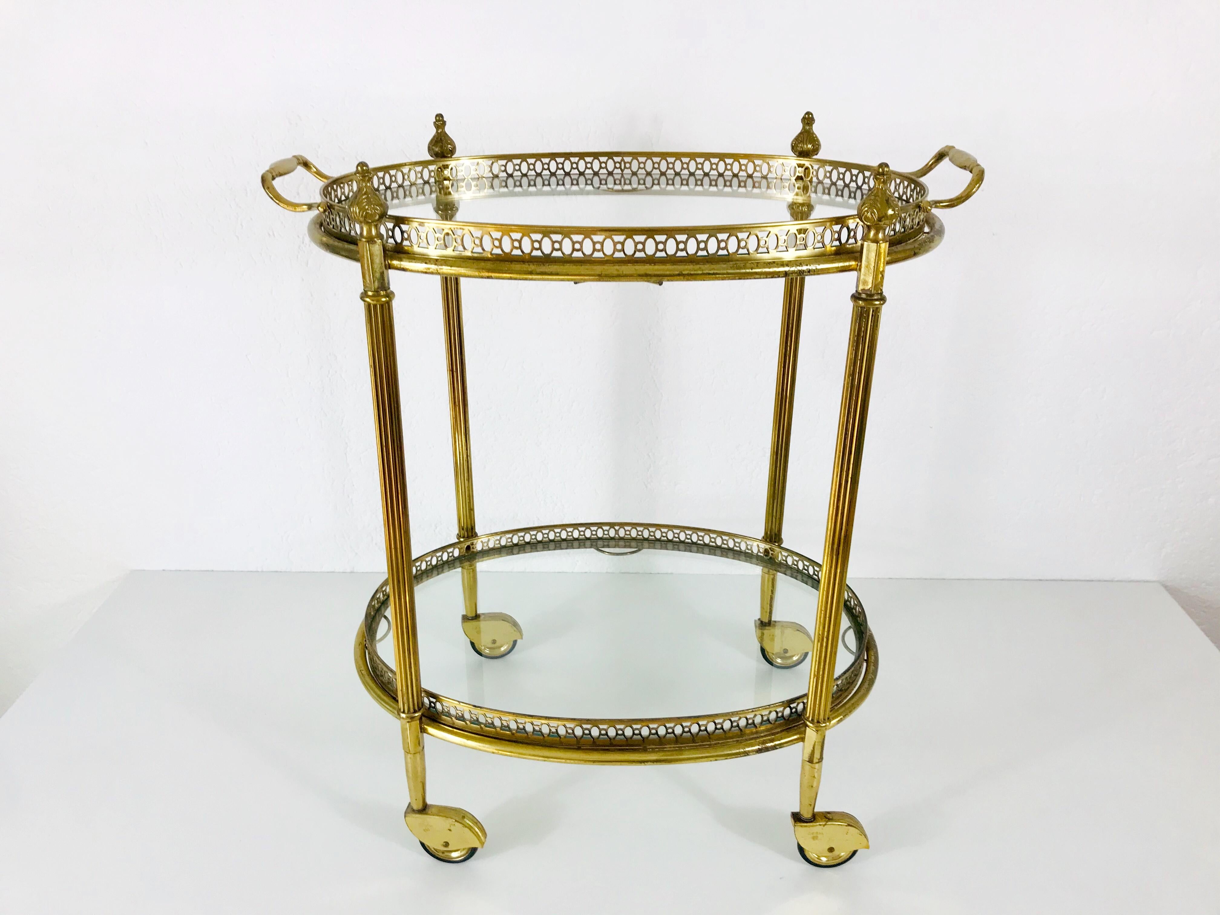 Midcentury trolley made in France in the 1950s. It has beautiful brass ornaments and two glass elements. Removable tray and four wheels. Very good vintage condition. The design is similar to the one by Maison Jansen.


  