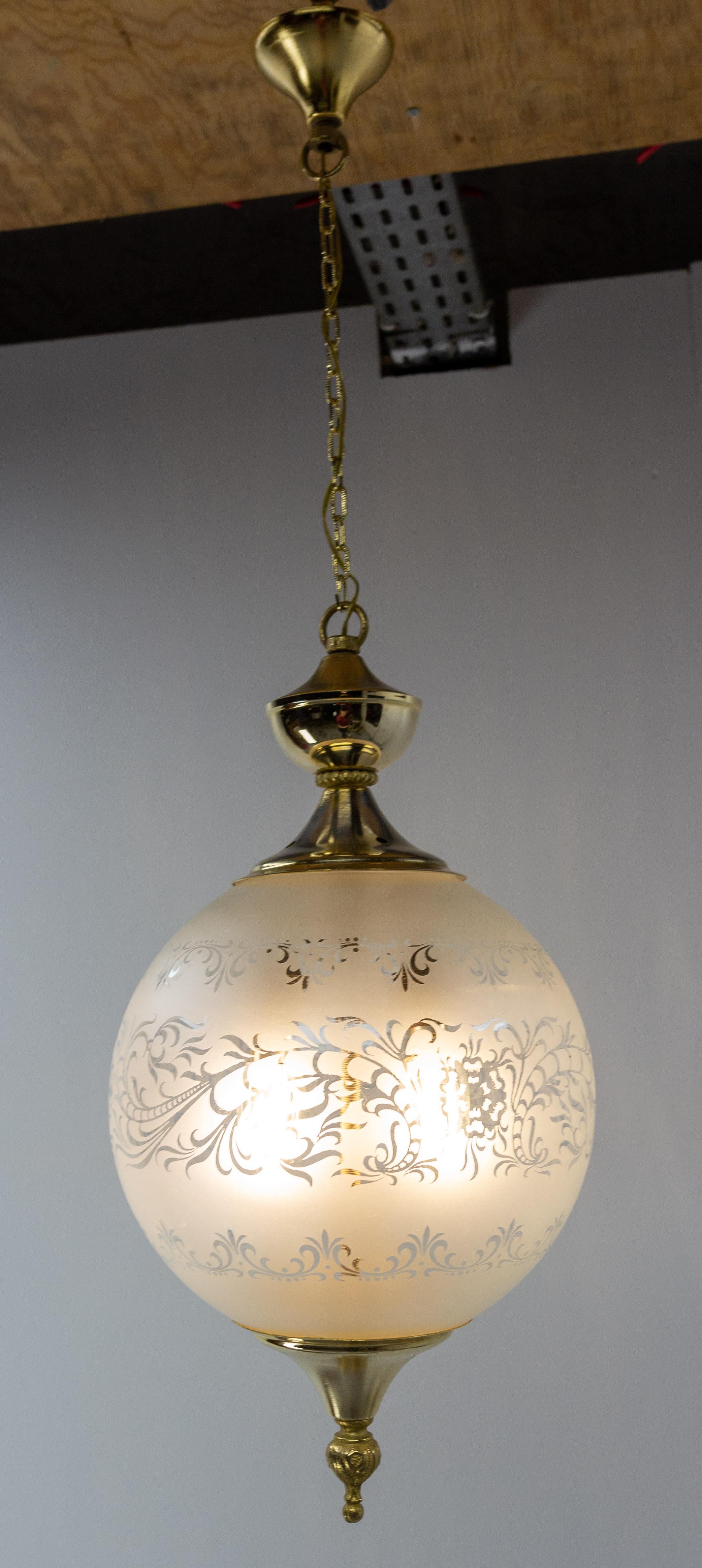 Hängeleuchte Kronleuchter, Frankreich, Mitte des Jahrhunderts.
Zwei Glühbirnen im Inneren der Lampe.
Die Glaskugel ist mit pflanzlichen Motiven verziert, die abwechselnd aus mattiertem und glattem Glas bestehen.
Messing und Glas, hergestellt in