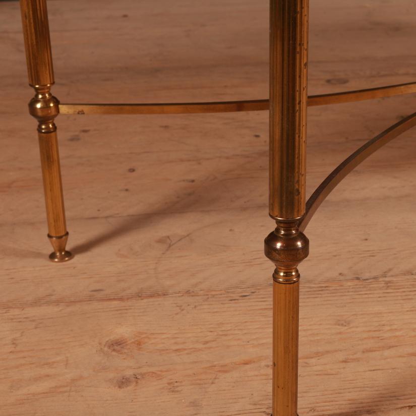 Large 1920s French brass and glass low table, 1920.

Dimensions:
47.5 inches (121 cms) wide
18 inches (46 cms) deep
16 inches (41 cms) high.

 