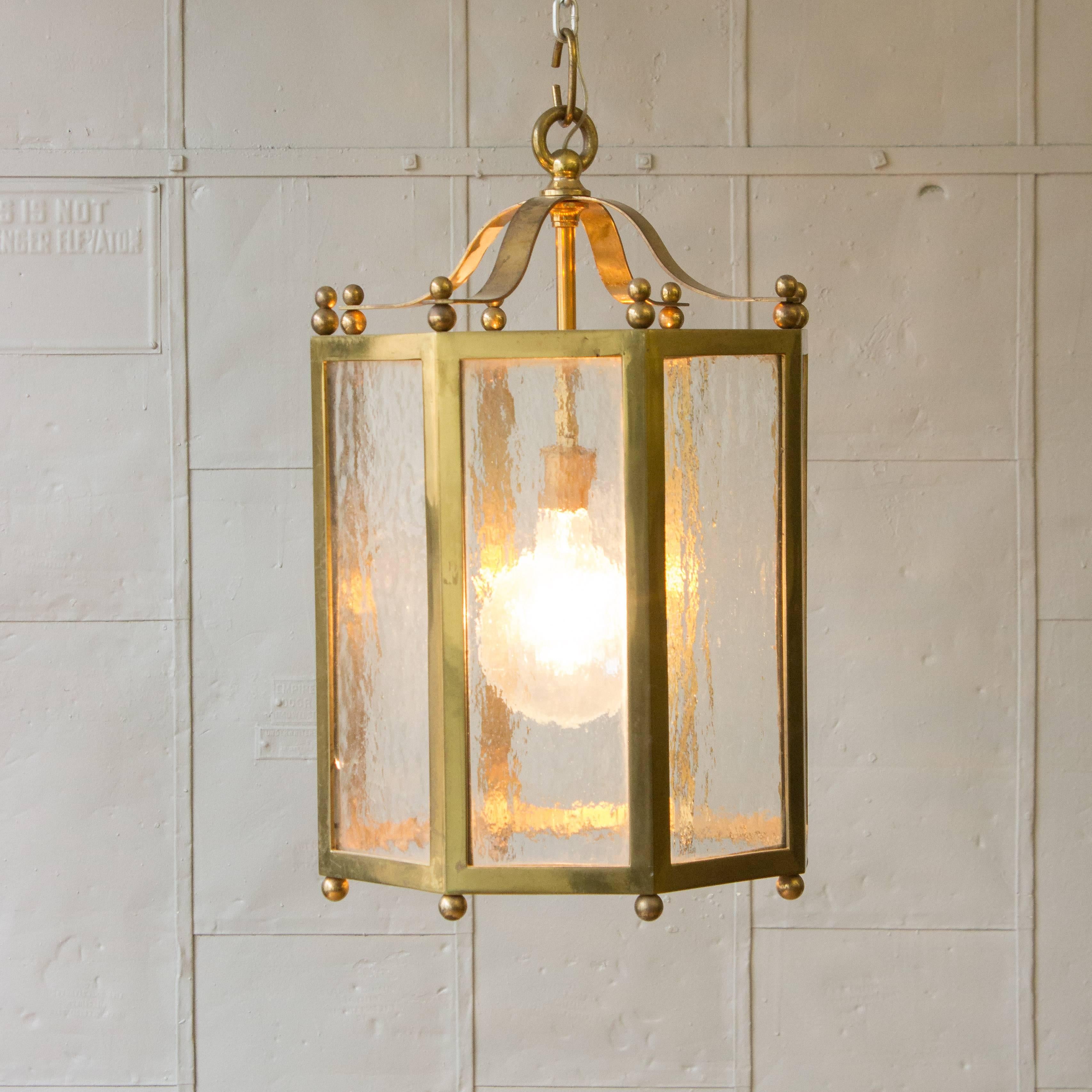 This elegant French eight sided hanging brass lantern will add a touch of sophistication to any room in your home. Boasting eight panes of textured glass set in an ornate brass structure, it provides the perfect balance of luxury and subtlety.