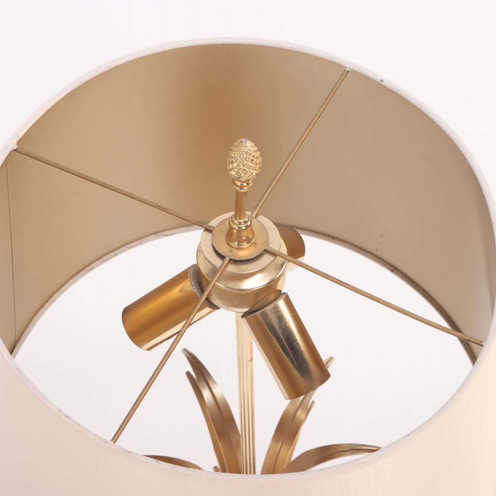 Lampe de table française en laiton et acier poli attribuée à la Maison Charles C 1950. La tige centrale est ornée de feuilles d'or s'évasant vers l'extérieur et sortant d'une base en forme d'urne. Abat-jour inclus.
