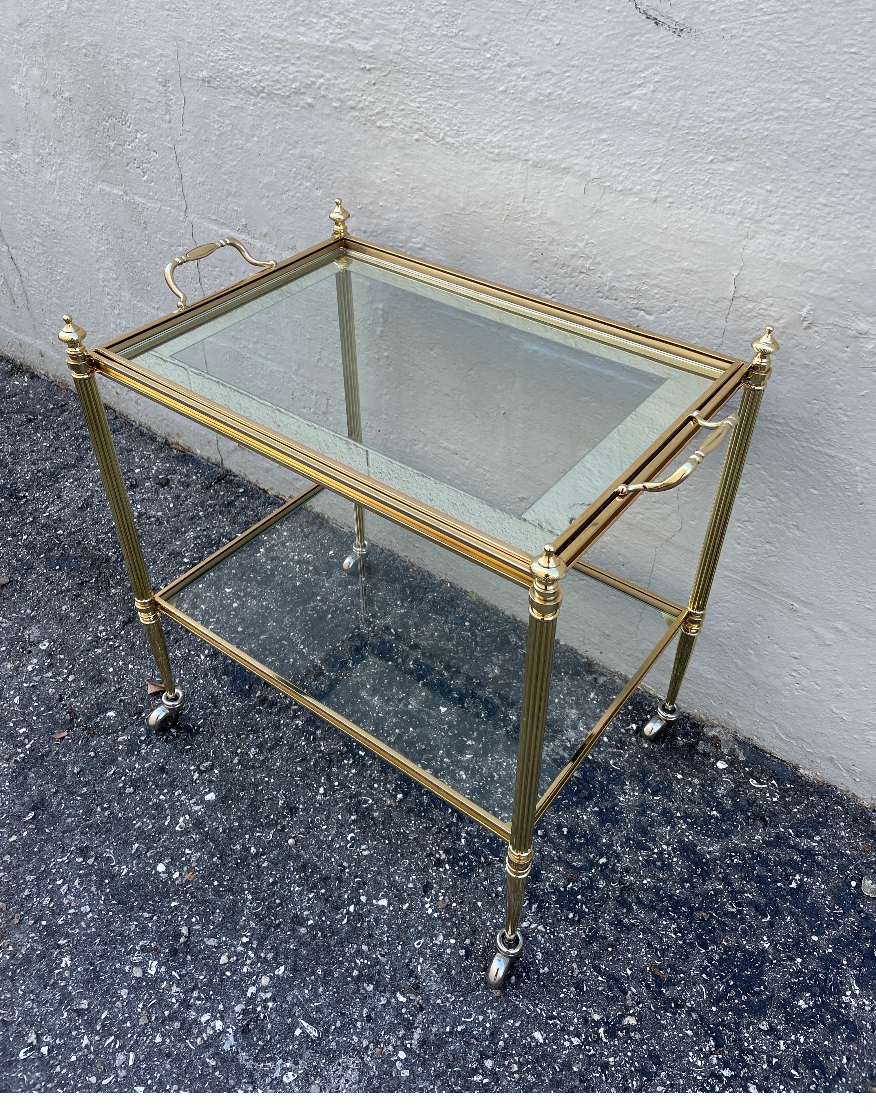 Very special brass bar cart by Jansen. Two shelves with removable top tray with mirrored border glass.
