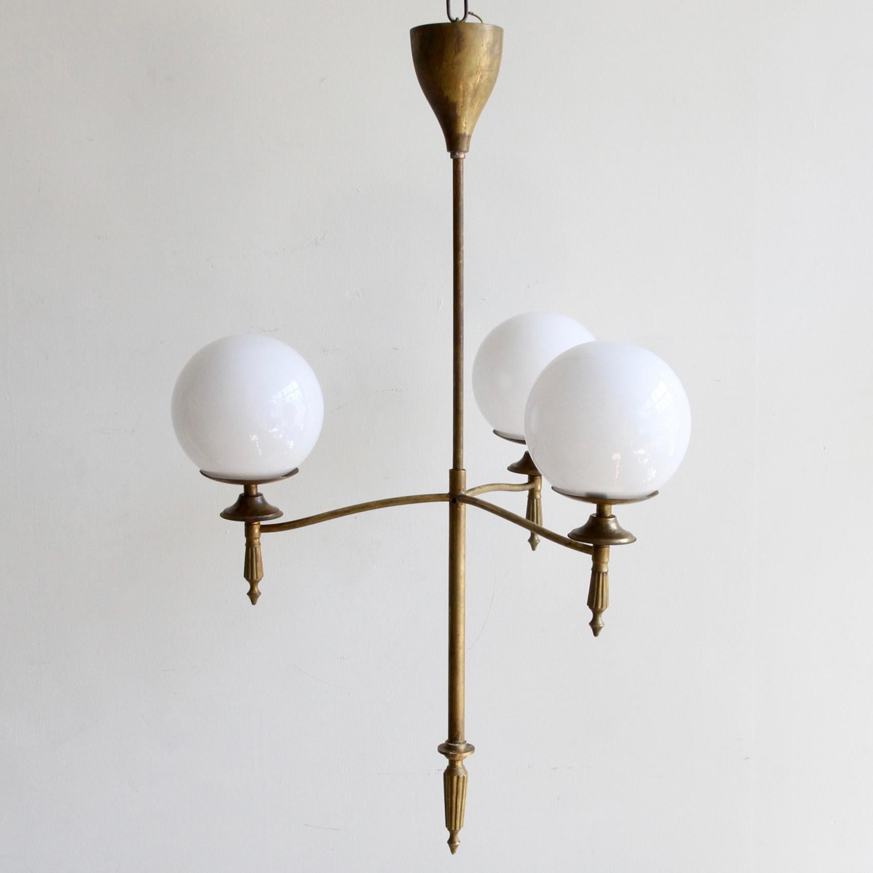Early 20th century French chandelier with three polished glass opaline shades. The shades sit beautifully on monk cap galleries supported by the delicate tubular frame. The brass has aged naturally to create the patina. The chandelier comes supplied