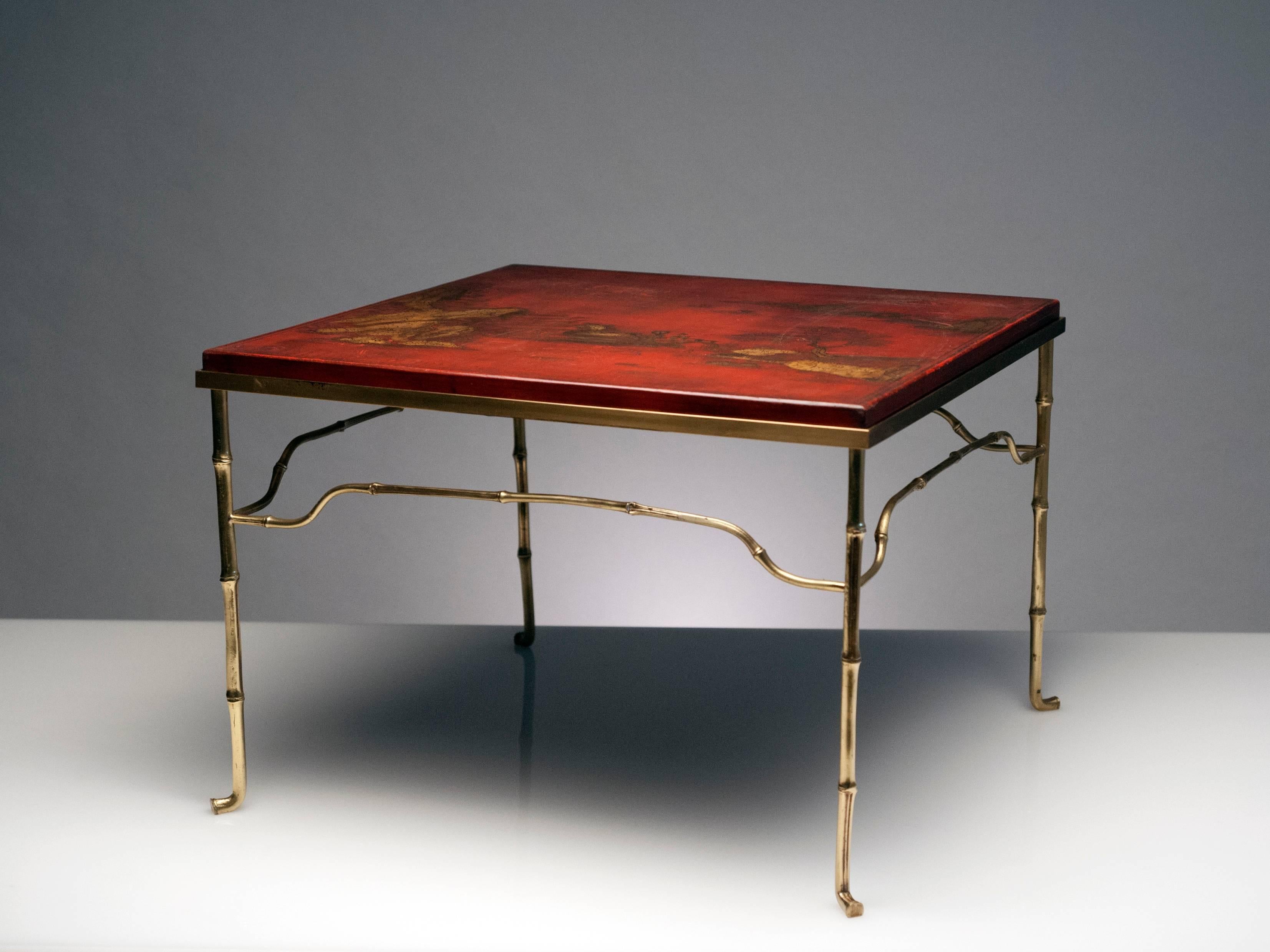 Unique and appealing French brass table with Asian antique top. Base is solid brass and top is antique red lacquered wood with Asian landscape. Handwritten Asian characters to underside.