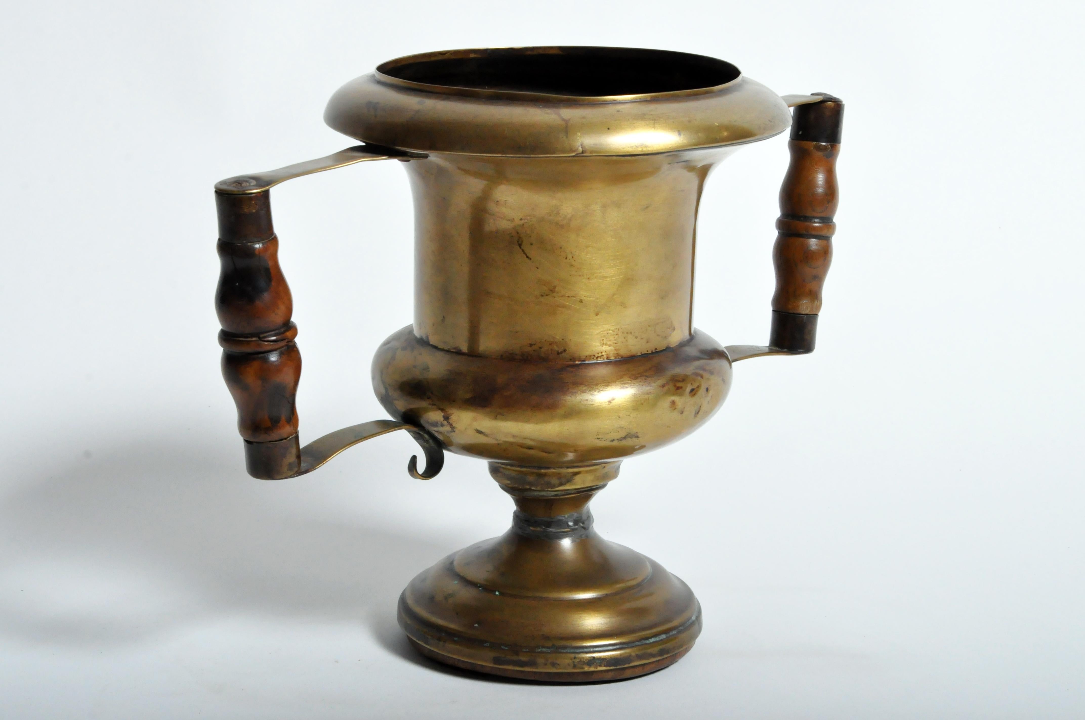 This cup is from France and was made from brass and oakwood, circa 1900.