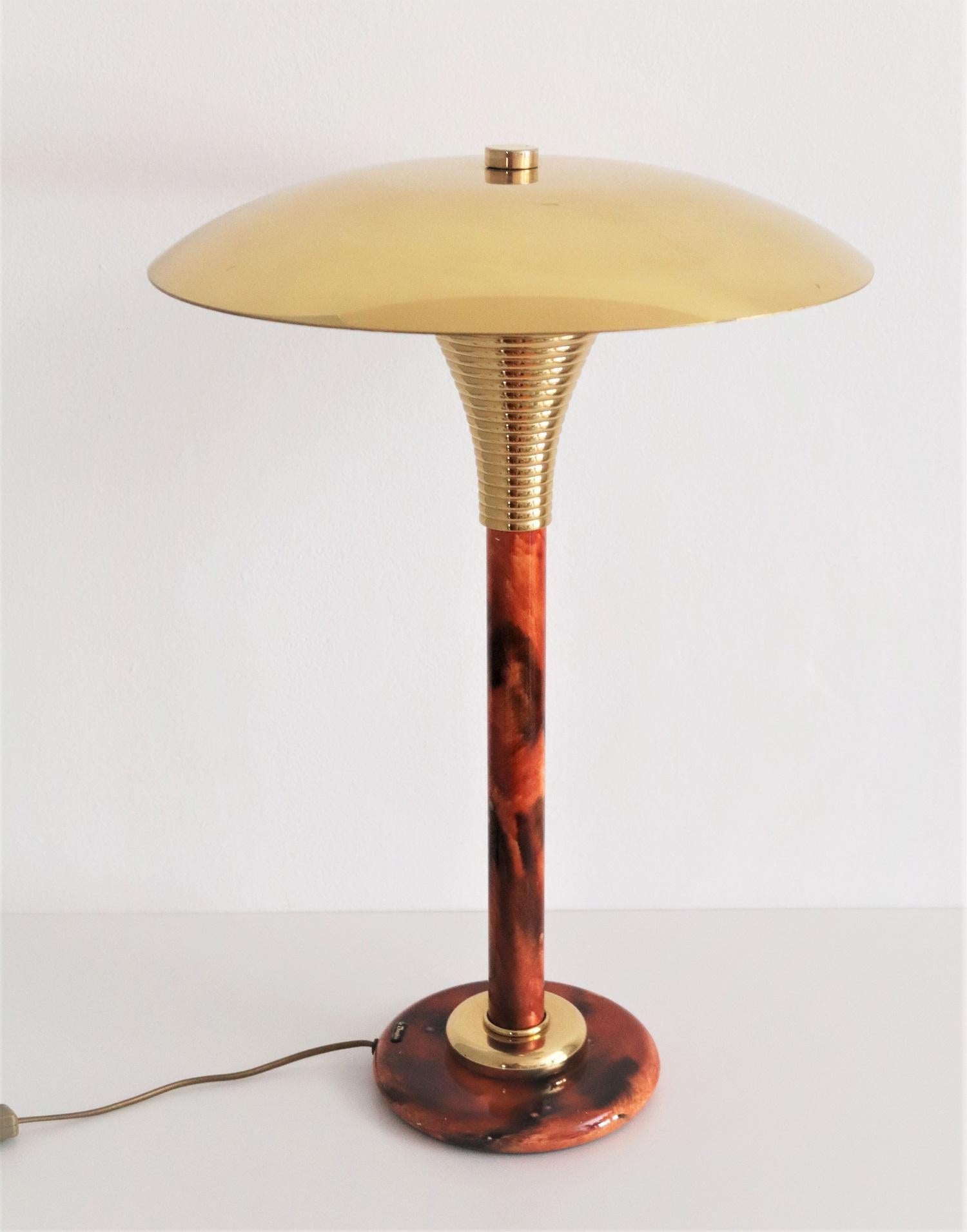 High desk or table lamp made of resin and shiny brass by Maison Le Dauphin, France in the 1970s.
The lamp has a shiny brass lamps top plate with brass screw and under the plate nice brass details.
The lamp's base is made of metal.
Signed with 