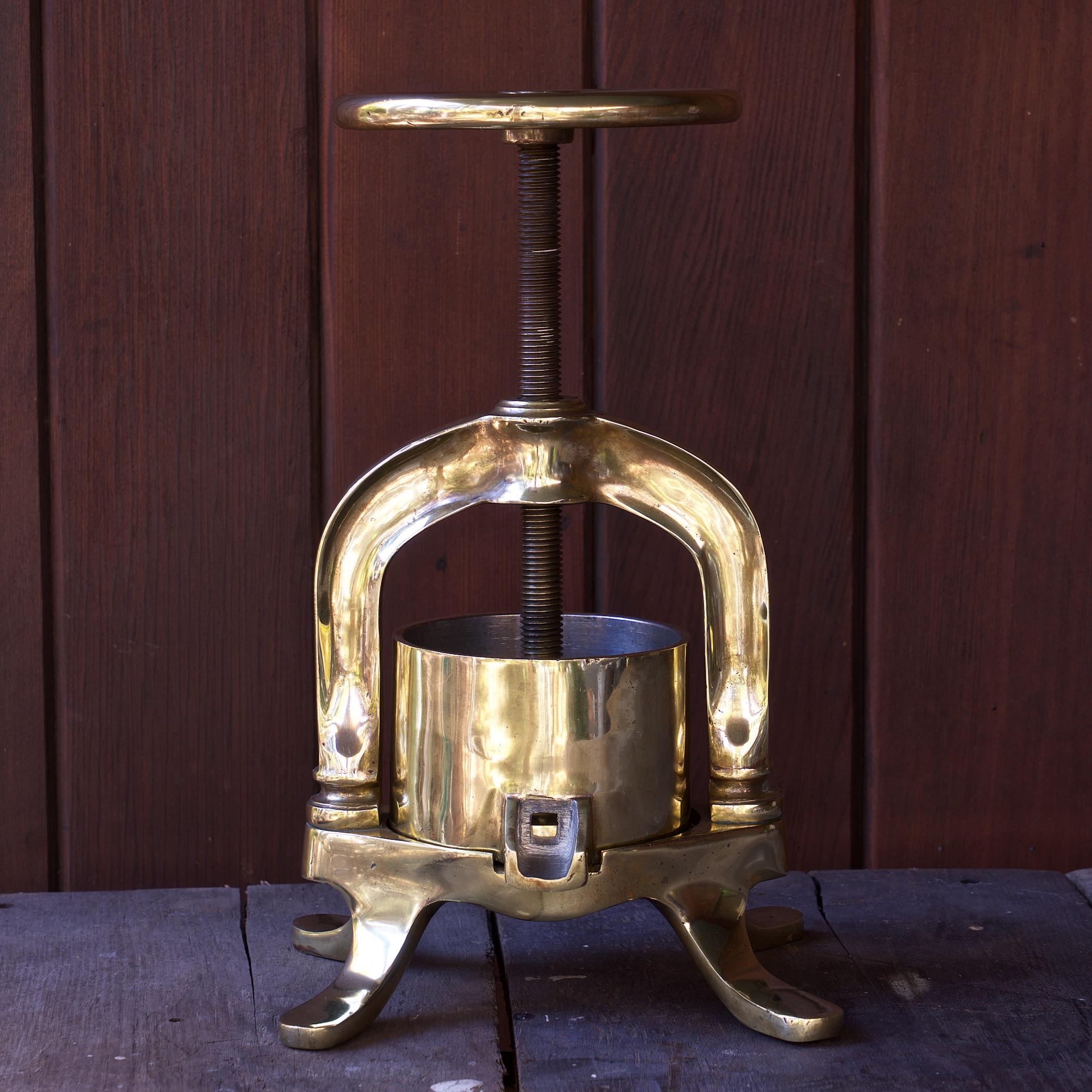 Patinated Polished Brass Duck Confit Press. Fully functional, runs smoothly.  There are no cracks or chips to the brass. This item came from very old Washington DC French Cooking School Teachers Estate. 

Wheel diameter is 5 inches.  Capacity is 3