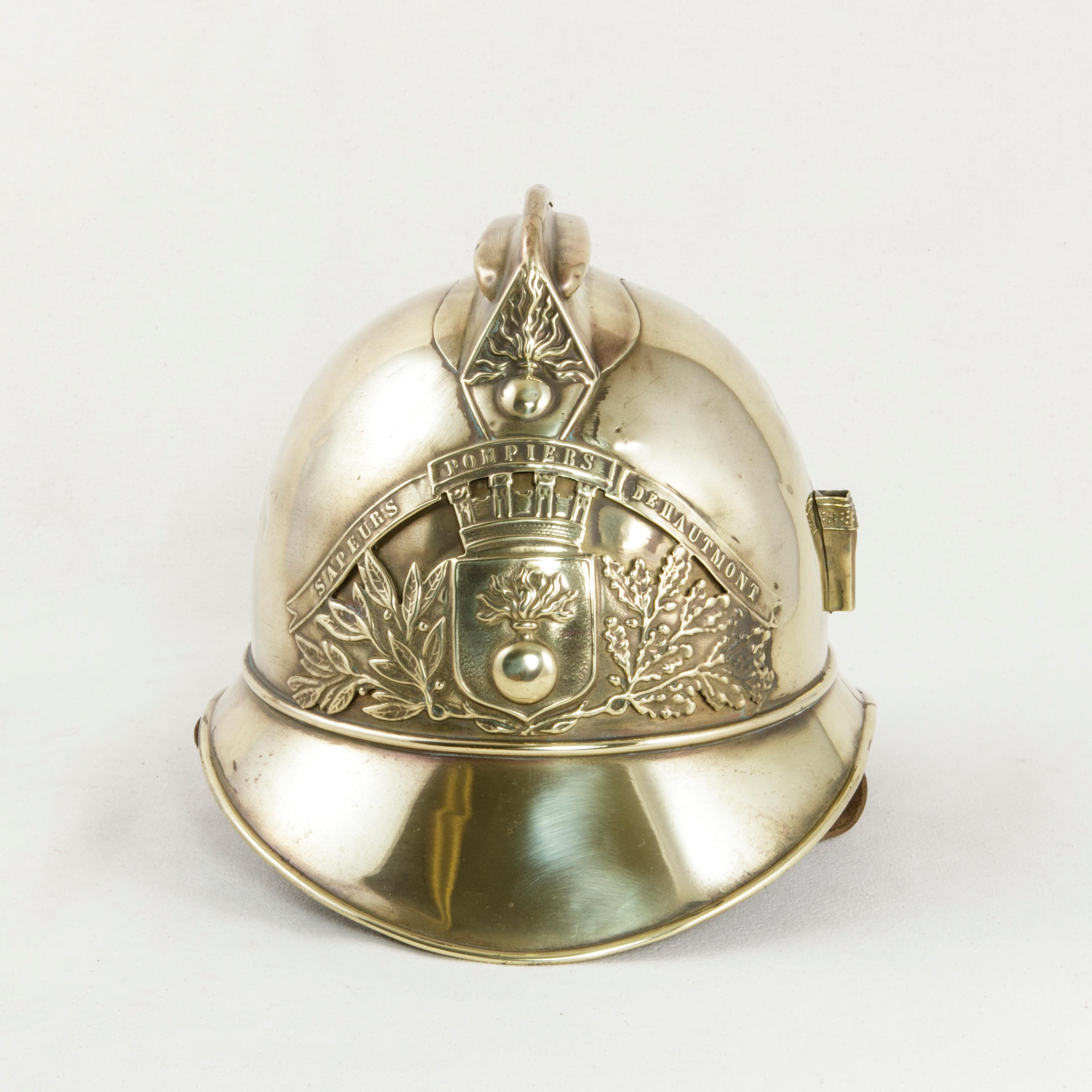 Fitted with its original leather chin strap and inner liner, this French brass fireman's helmet takes the form of a French military helmet, a style frequently seen during the First World War. The front plate of the helmet bears the Classic French