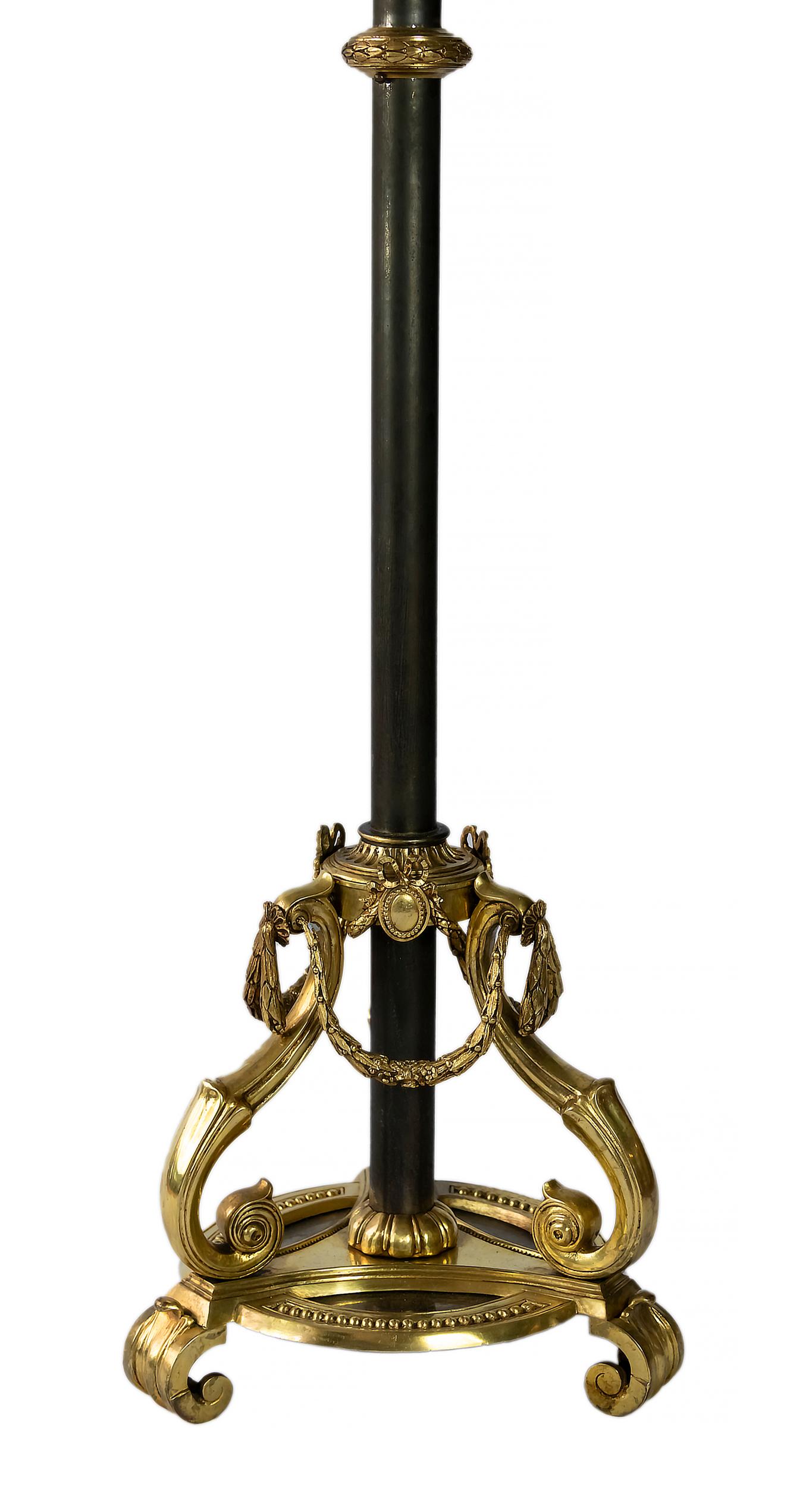 French floor lamp in brass with a very decorative base.
The lamp is with new made satin finish black color textile shade with gold inside.
There are 3 bulbs E27.

 