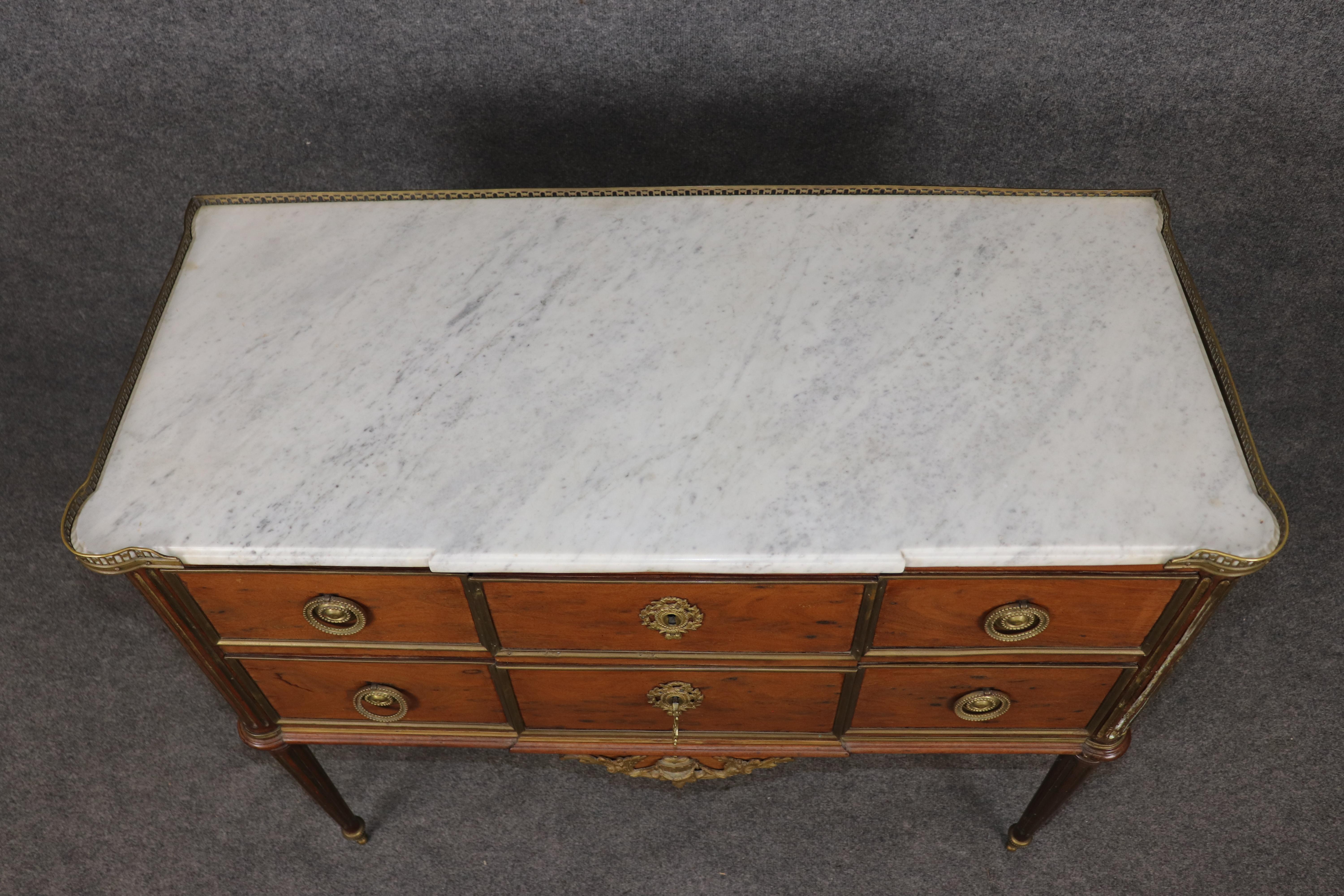 Si tratta di una rara commode in mogano acajou e gambe scanalate in ottone con piano in marmo di Carrara. Il mobile è realizzato in raro mogano acajou. La custodia è sbiadita ma il resto è in buone condizioni con lievi segni di età e usura. Il pezzo