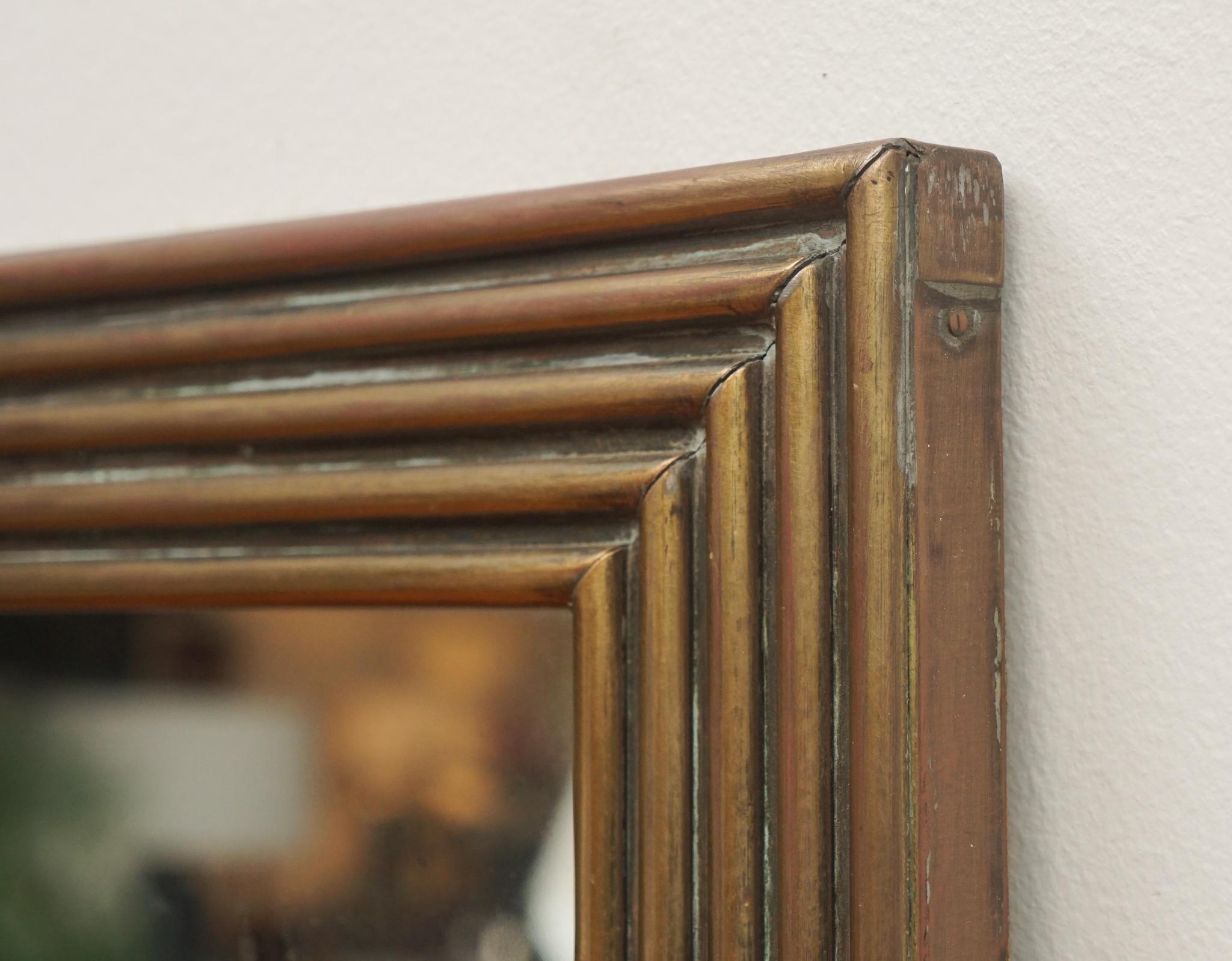 Avec sa faible largeur et ses détails en escalier, ce miroir français vintage encadré de laiton est parfait pour les endroits où l'espace mural est limité.  A considérer comme un miroir d'entrée ou de fin de couloir.  Quel que soit l'endroit où il