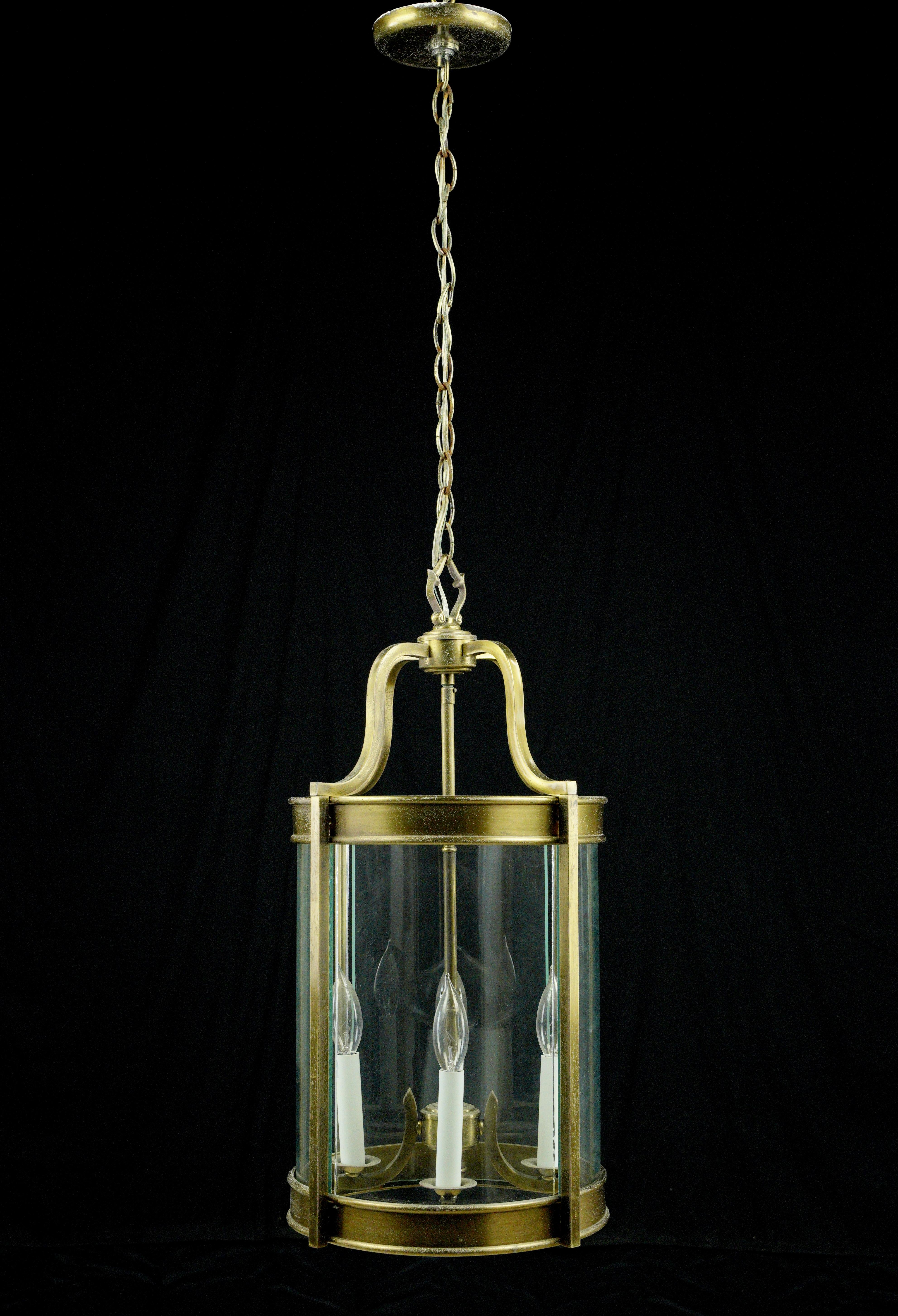 This cast brass pendant features bent glass segments forming a cylinder and topped with elegant solid brass brackets, four candle lights, and a matching chain and canopy. This light requires four candelabra light bulbs. Good condition with