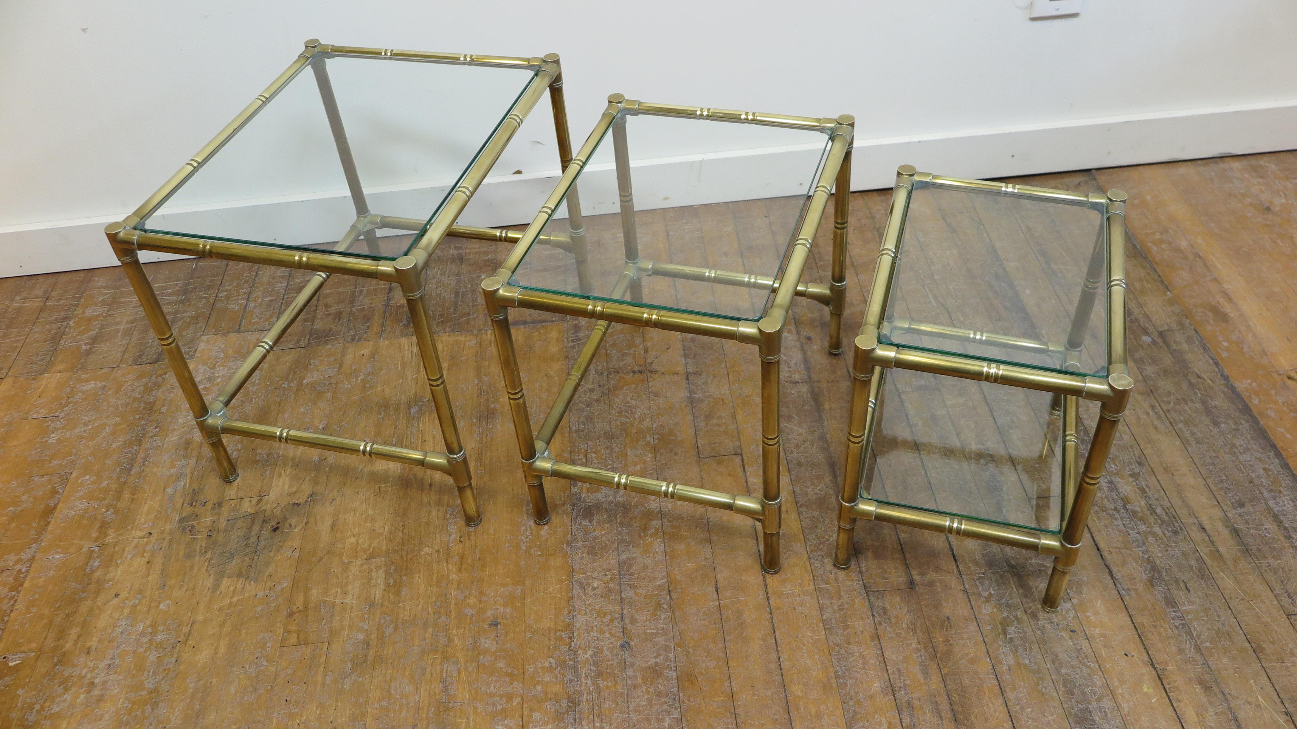 French midcentury brass and glass set of 3 nesting tables. Modernist brass faux bamboo styled nesting tables. Tables are high quality brass construction with brass joining's. Very good condition. Patina to the brass, all the glass tops are new. The